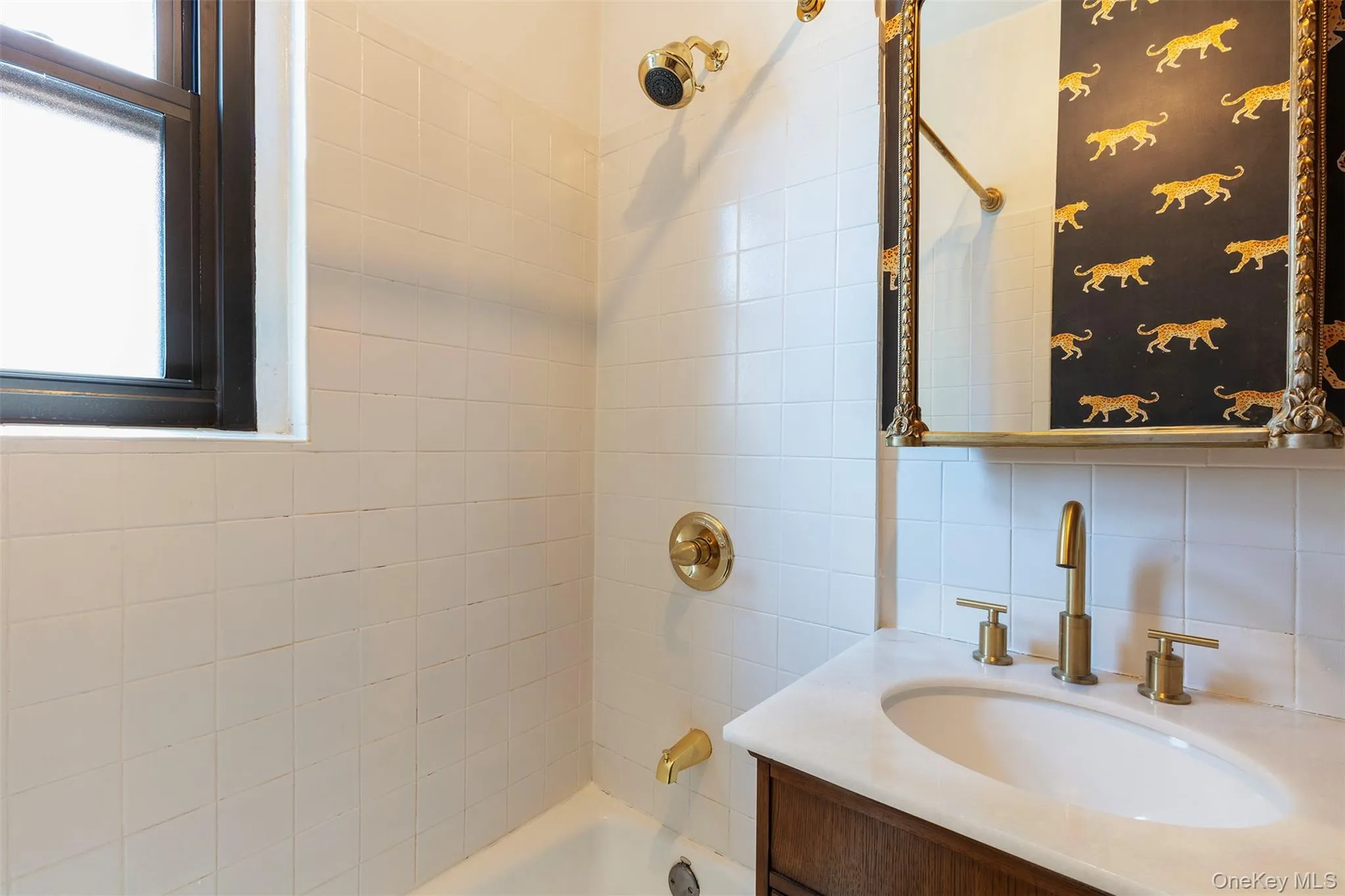 Full bathroom with vanity, washtub / shower combination, plenty of natural light, and backsplash Full bathroom with vanity, washtub / shower combination, plenty of natural light, and backsplash