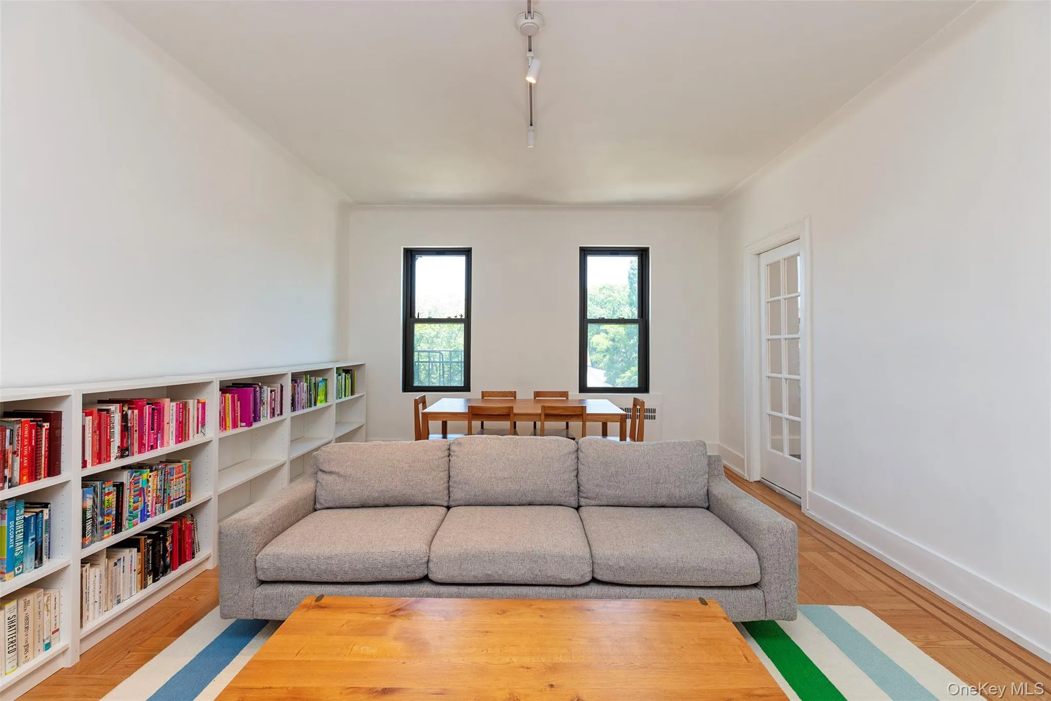Living room with baseboards, wood finished floors, and track lighting Living room with baseboards, wood finished floors, and track lighting