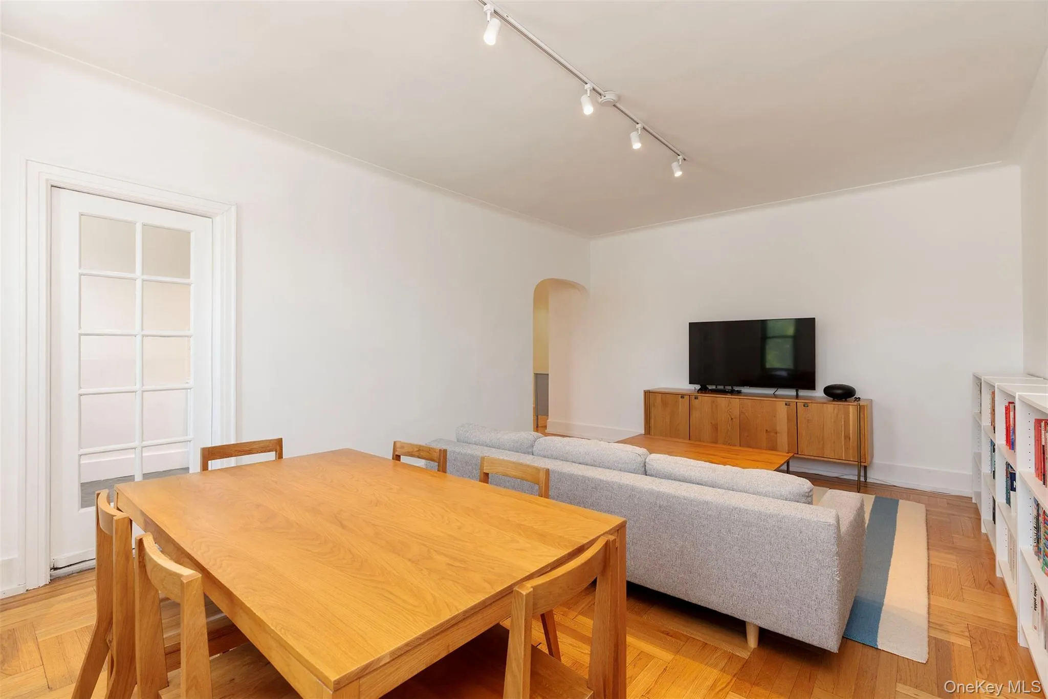 Dining area with track lighting, arched walkways, and baseboards Dining area with track lighting, arched walkways, and baseboards