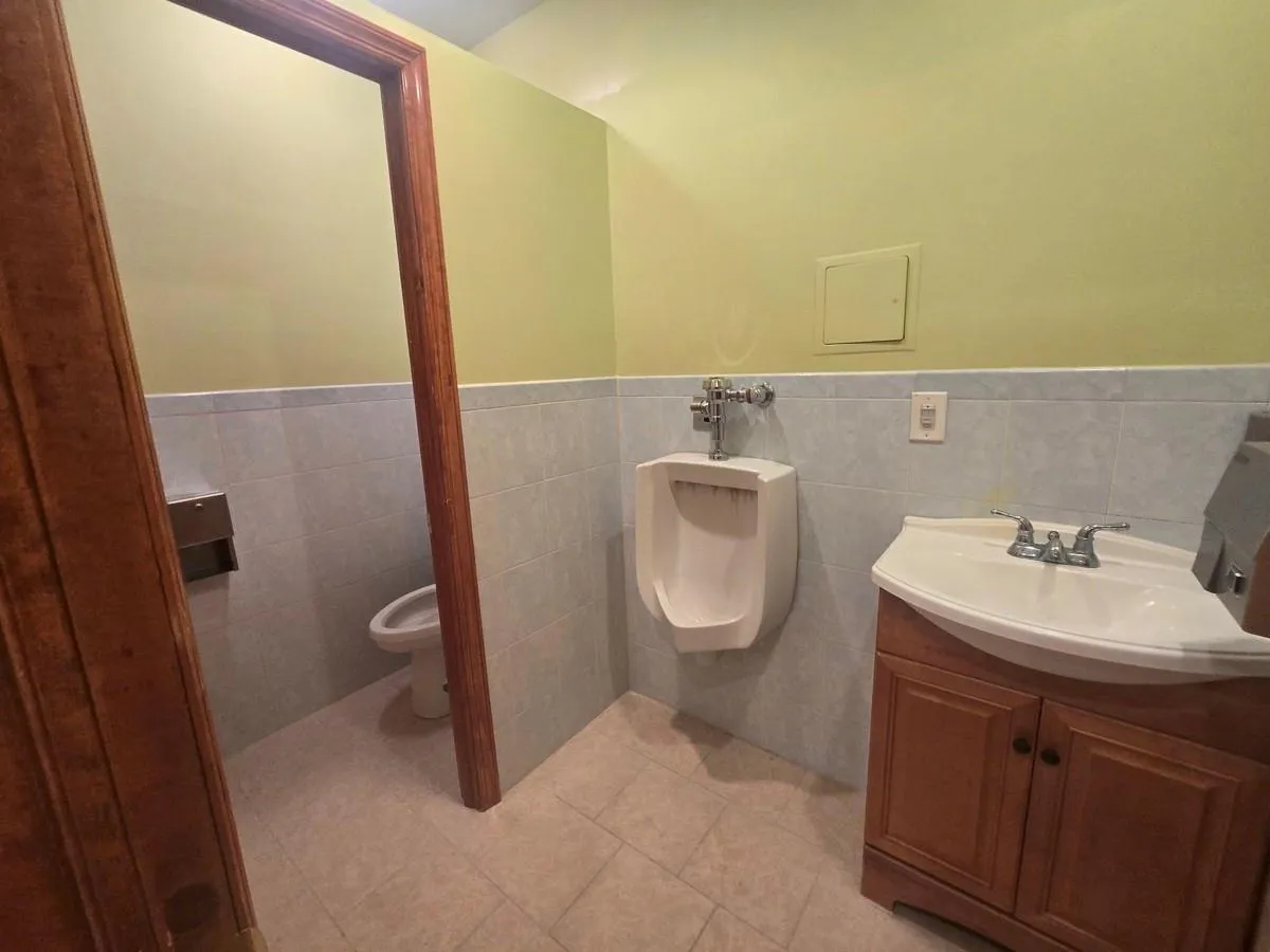Bathroom featuring vanity, wainscoting, toilet, and tile walls Bathroom featuring vanity, wainscoting, toilet, and tile walls