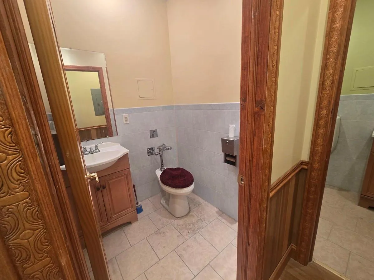 Bathroom featuring wainscoting, vanity, tile walls, toilet, and tile patterned floors Bathroom featuring wainscoting, vanity, tile walls, toilet, and tile patterned floors