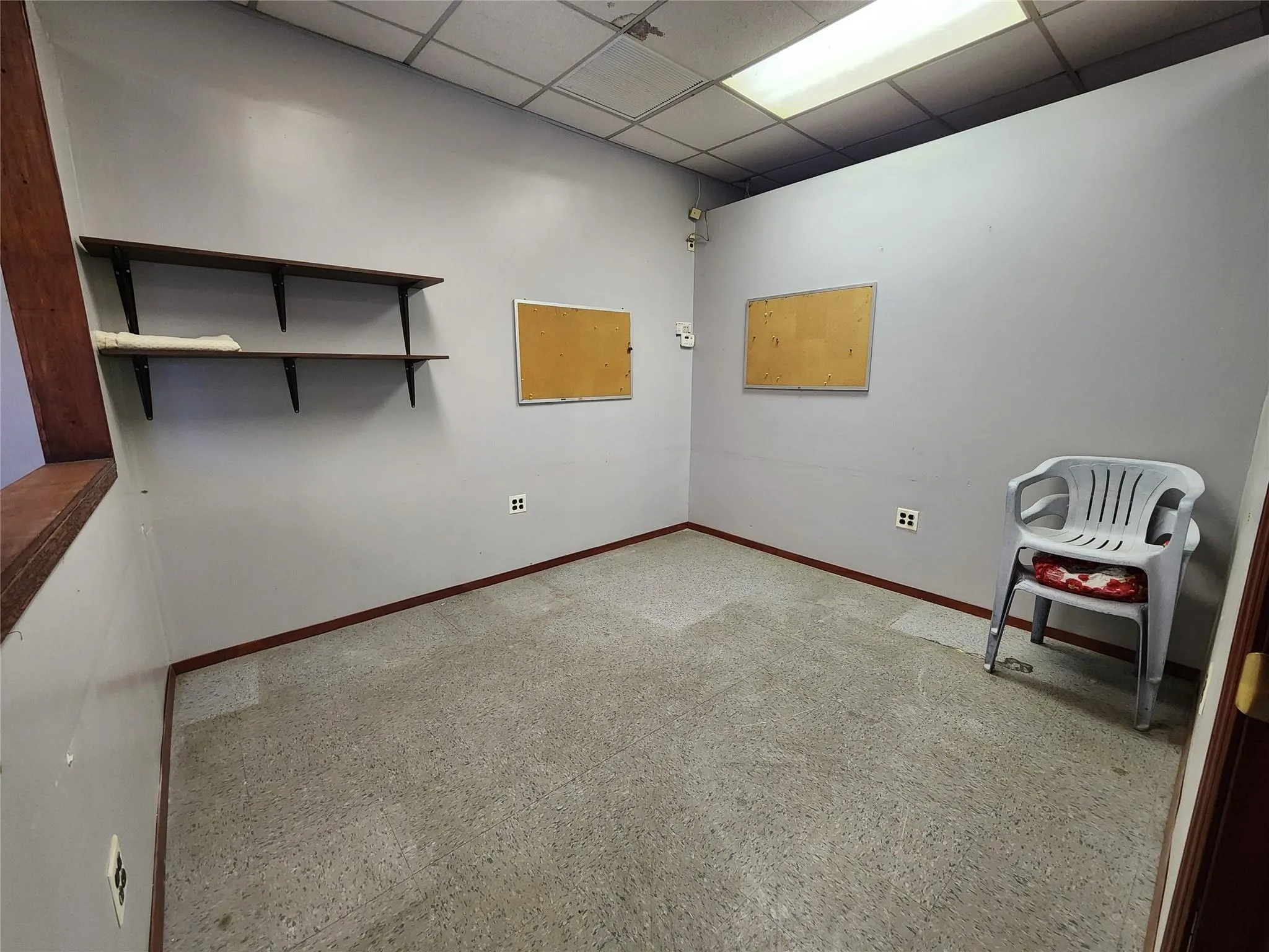 Empty room with baseboards and a drop ceiling Empty room with baseboards and a drop ceiling