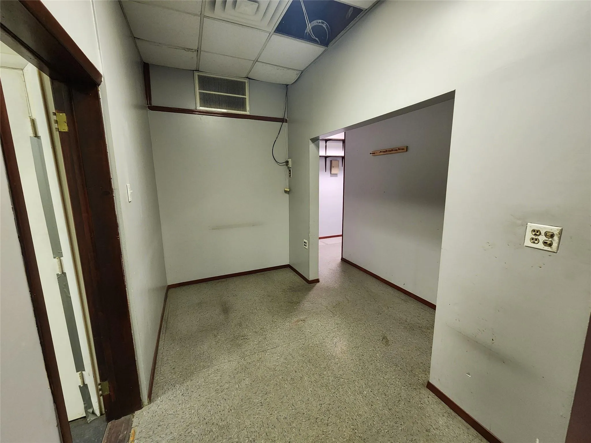Hallway with baseboards and a drop ceiling Hallway with baseboards and a drop ceiling