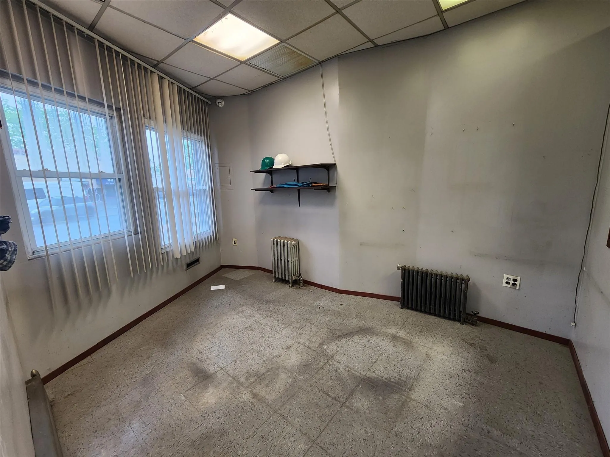 Unfurnished room featuring radiator heating unit and baseboards Unfurnished room featuring radiator heating unit and baseboards