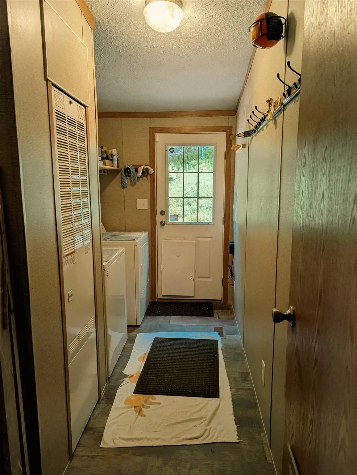 Laundry room with washer and clothes dryer, a textured ceiling, and a heating unit Laundry room with washer and clothes dryer, a textured ceiling, and a heating unit