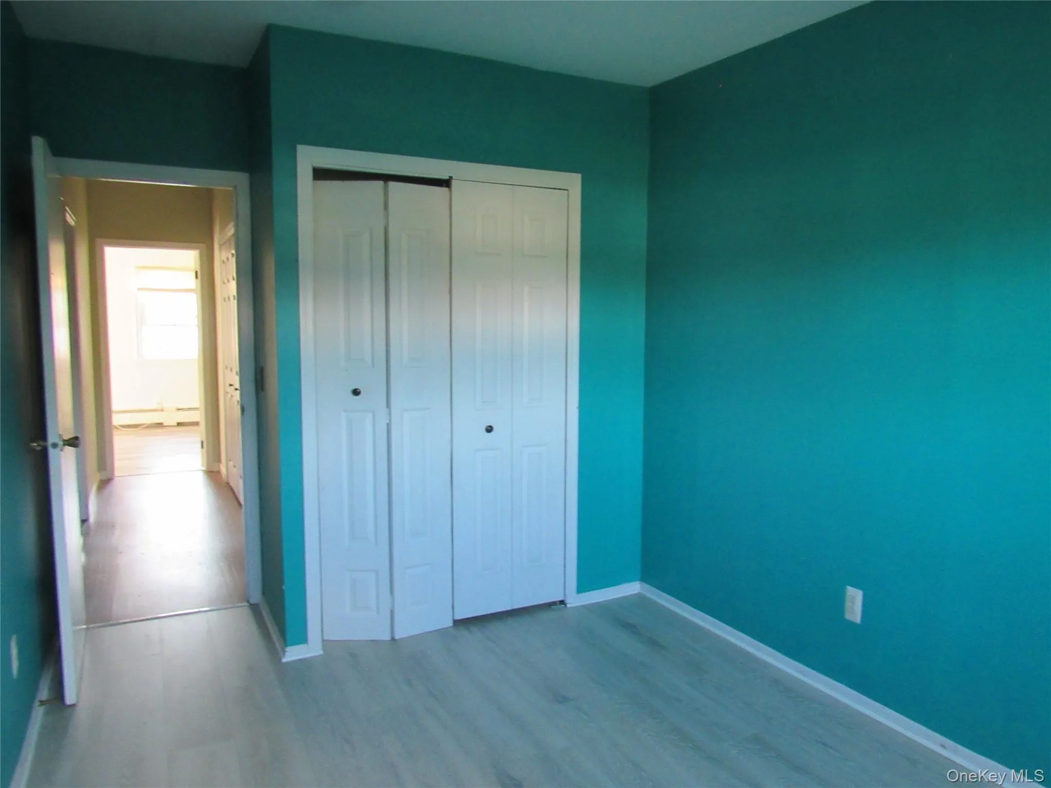 Unfurnished bedroom with wood finished floors and a closet Unfurnished bedroom with wood finished floors and a closet
