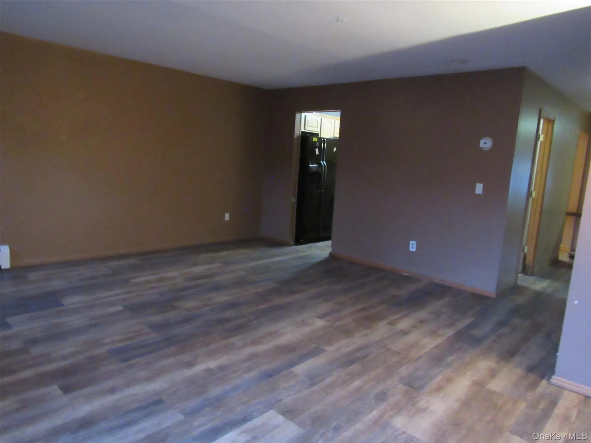Spare room featuring dark wood-style floors and baseboards Spare room featuring dark wood-style floors and baseboards