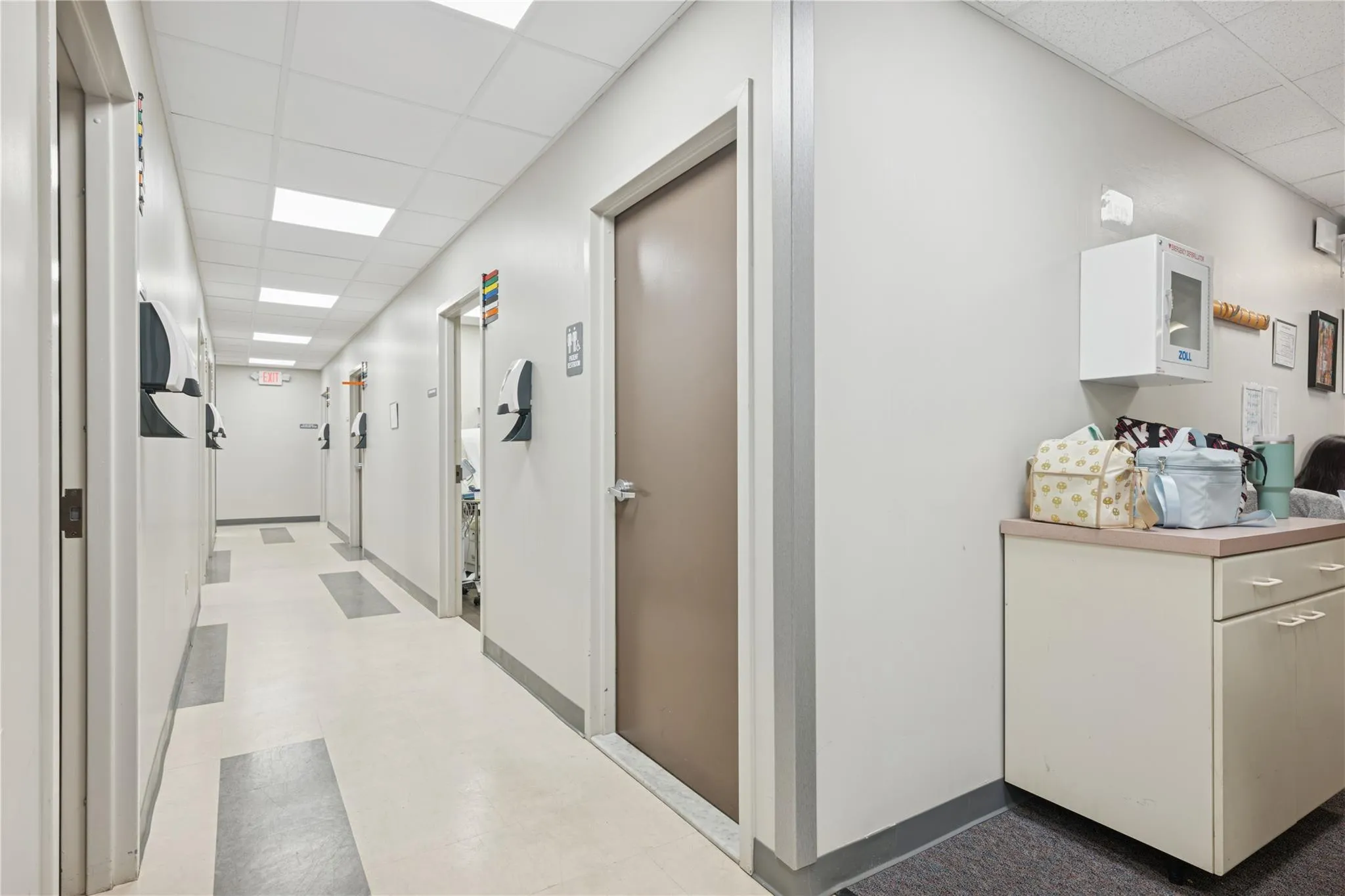 Hallway featuring a paneled ceiling and tile patterned floors Hallway featuring a paneled ceiling and tile patterned floors