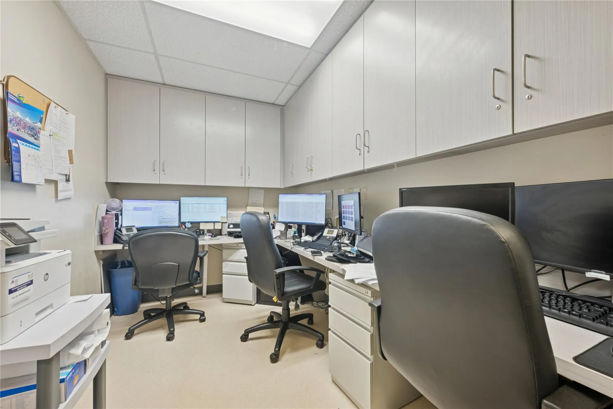 Office area featuring a drop ceiling and light colored carpet Office area featuring a drop ceiling and light colored carpet