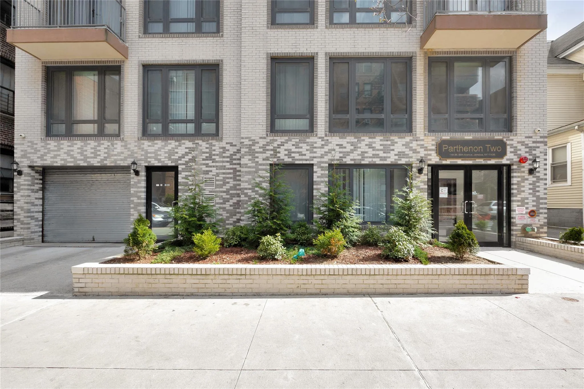 View of property featuring a garage, brick siding, and driveway View of property featuring a garage, brick siding, and driveway