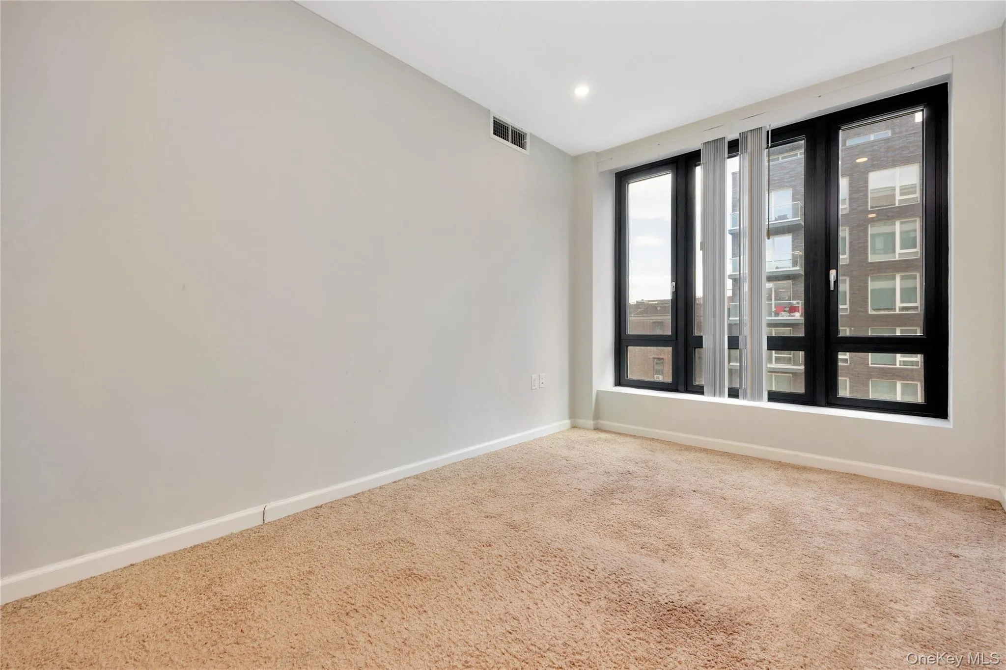 Carpeted spare room with recessed lighting, visible vents, and baseboards Carpeted spare room with recessed lighting, visible vents, and baseboards