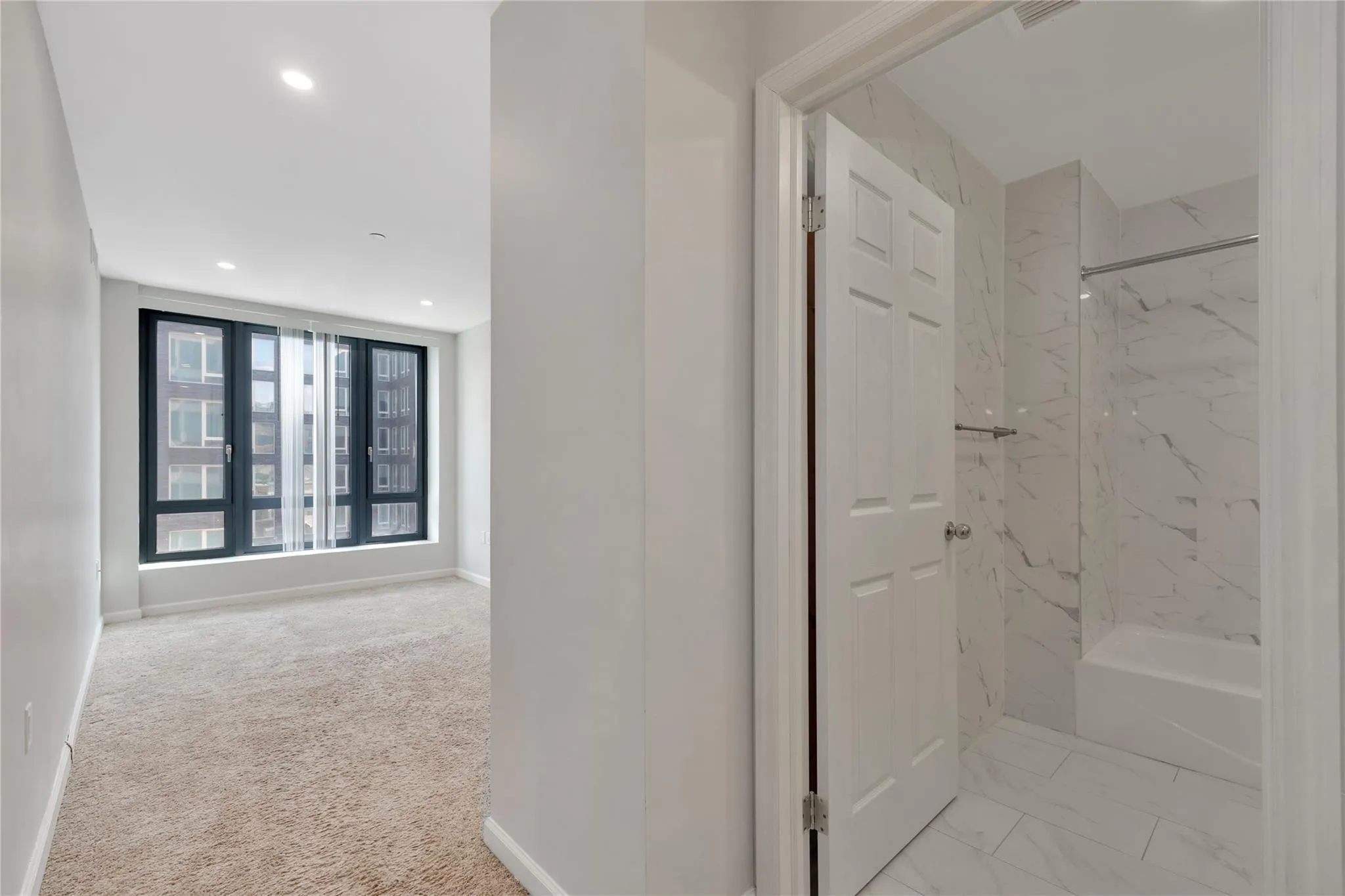 Corridor with baseboards, recessed lighting, carpet flooring, and marble finish floor Corridor with baseboards, recessed lighting, carpet flooring, and marble finish floor