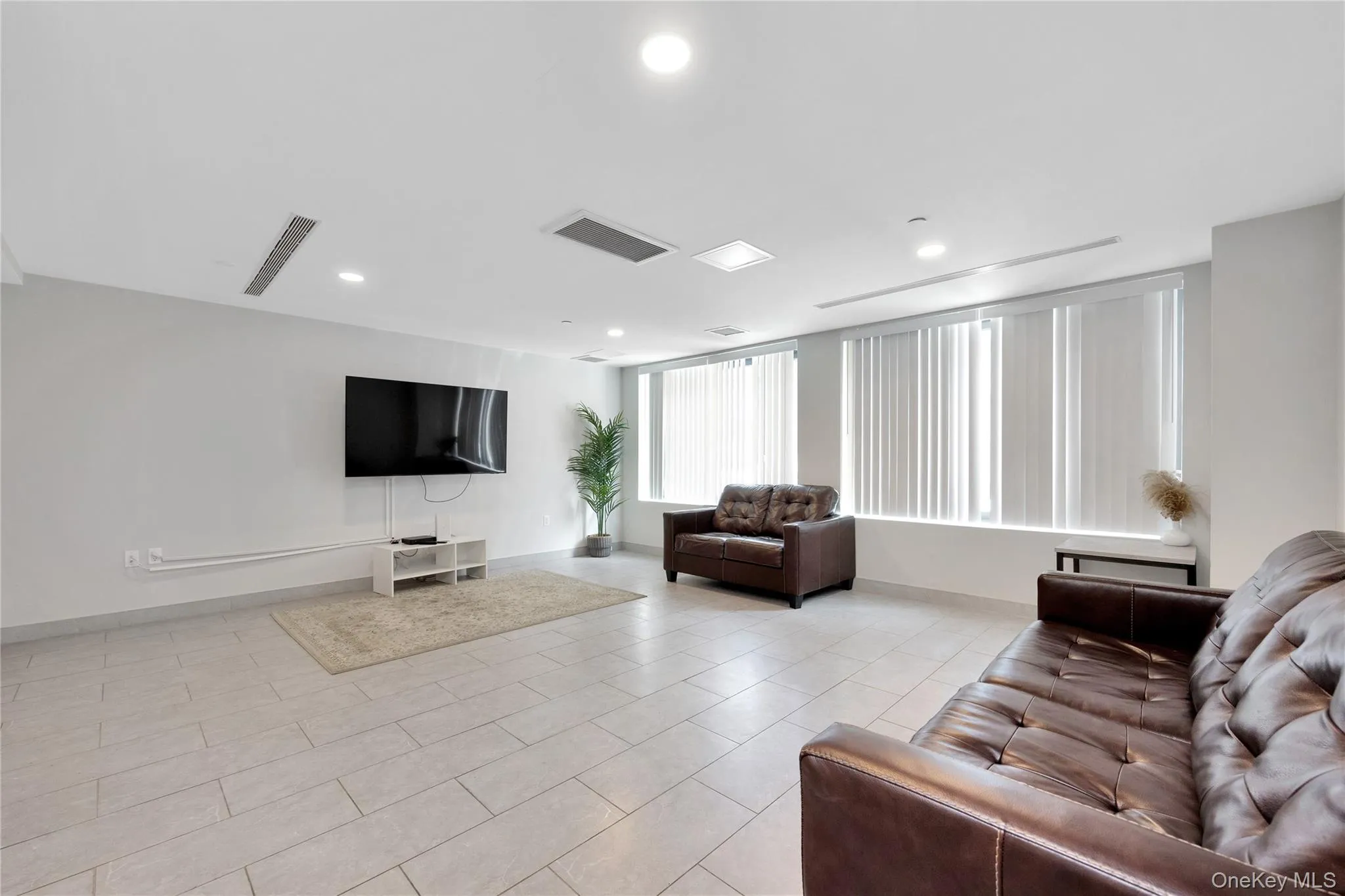 Living room featuring recessed lighting, light tile patterned floors, visible vents, and baseboards Living room featuring recessed lighting, light tile patterned floors, visible vents, and baseboards