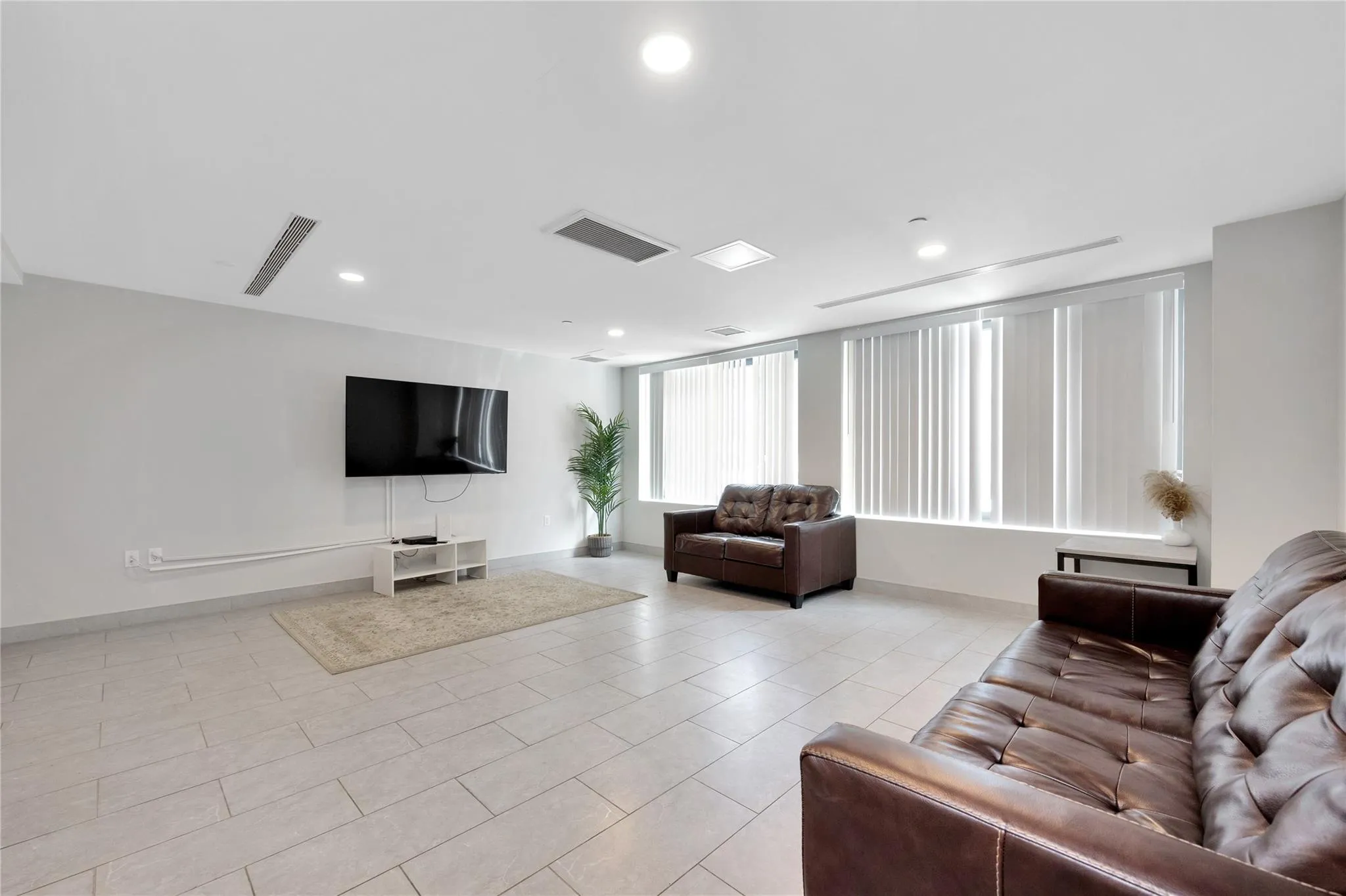 Living room featuring recessed lighting, light tile patterned floors, visible vents, and baseboards Living room featuring recessed lighting, light tile patterned floors, visible vents, and baseboards