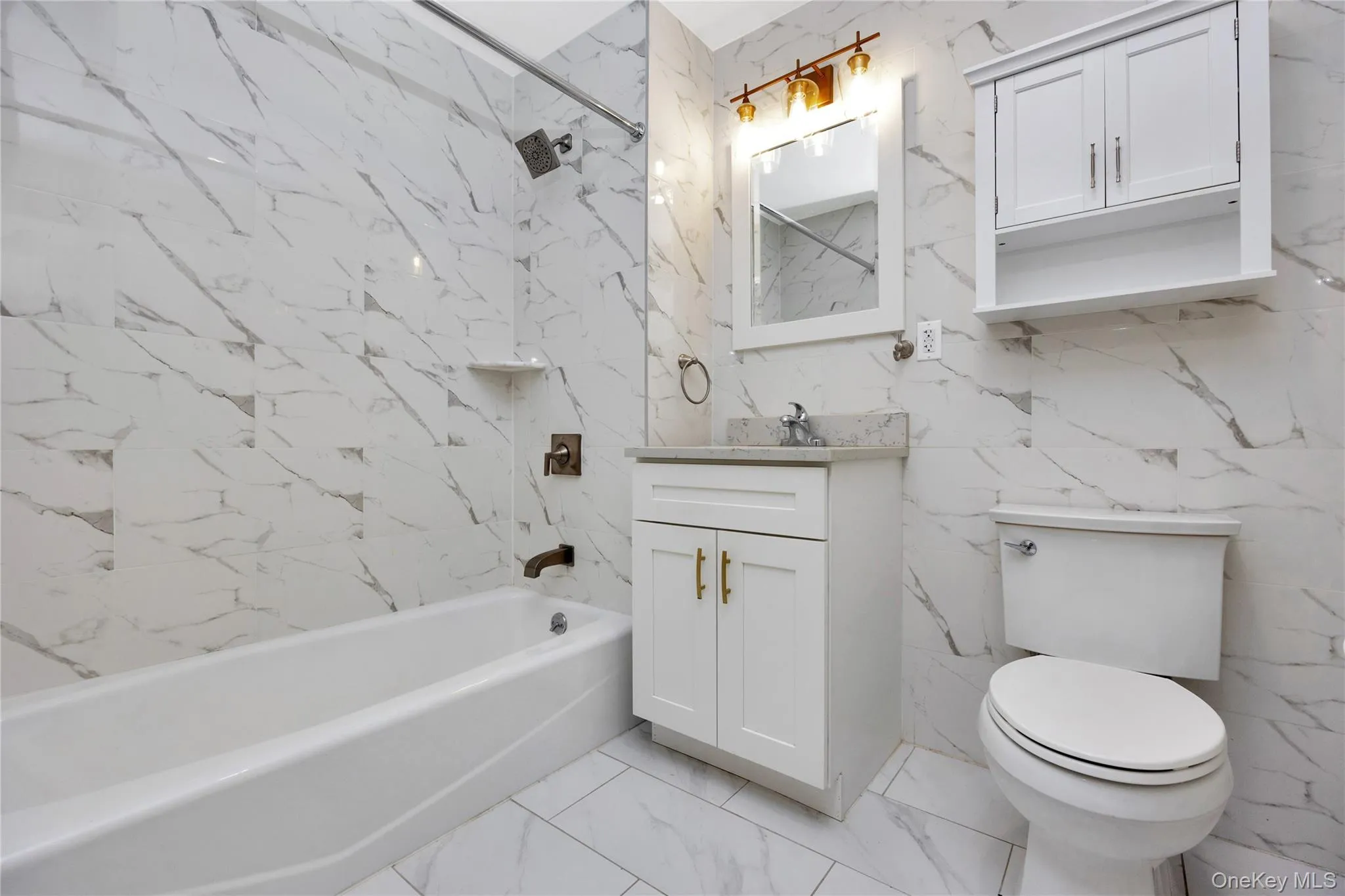 Bathroom featuring stone wall, shower / washtub combination, vanity, toilet, and marble finish floor Bathroom featuring stone wall, shower / washtub combination, vanity, toilet, and marble finish floor