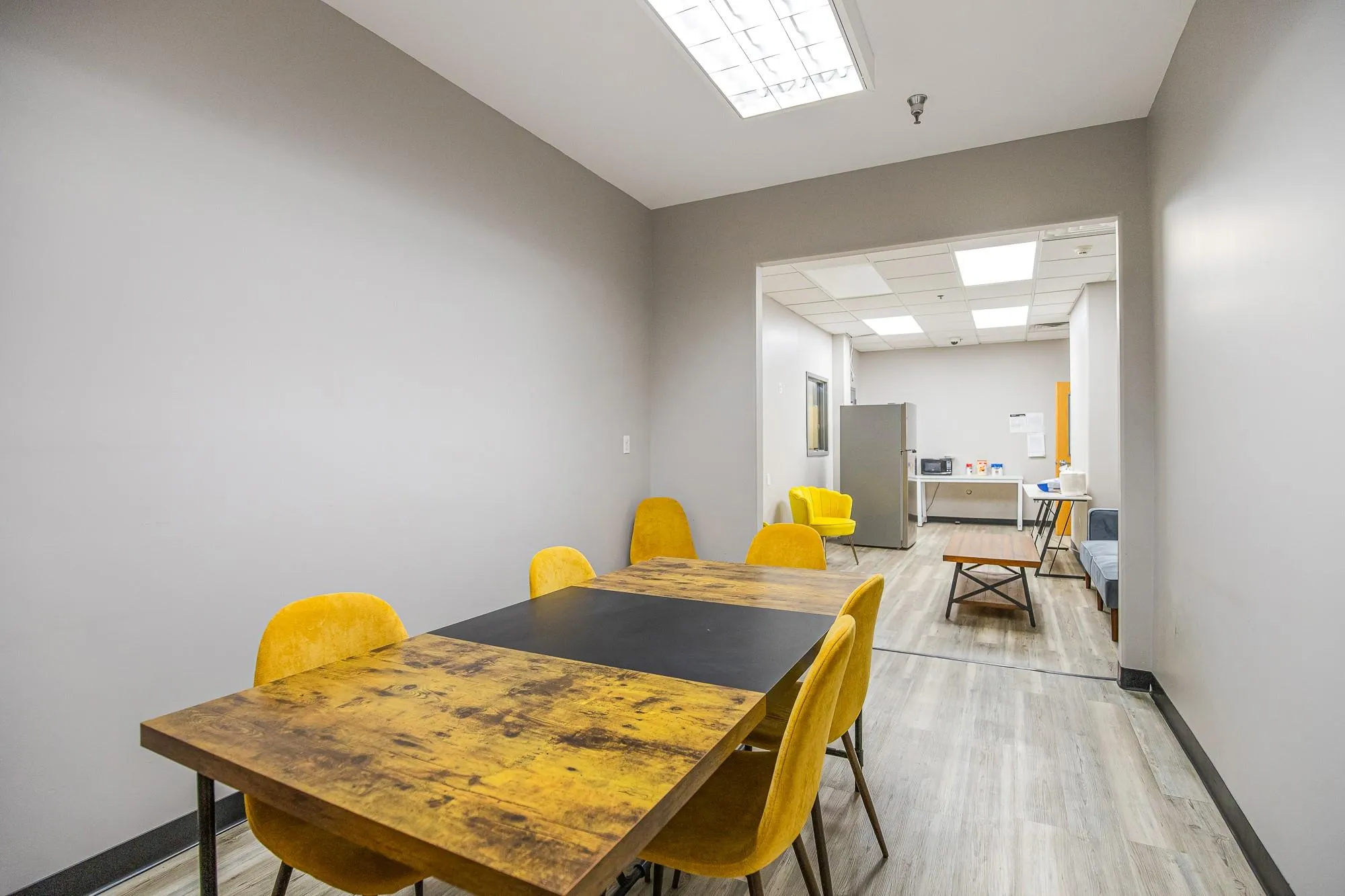 Dining area with a drop ceiling, light wood-style floors, and baseboards Dining area with a drop ceiling, light wood-style floors, and baseboards