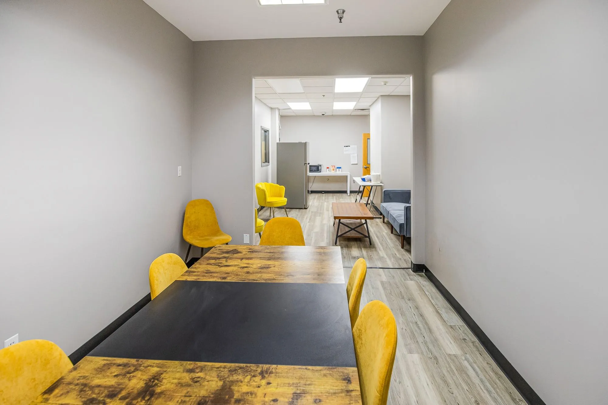 Dining space featuring light wood-style flooring, a drop ceiling, and baseboards Dining space featuring light wood-style flooring, a drop ceiling, and baseboards