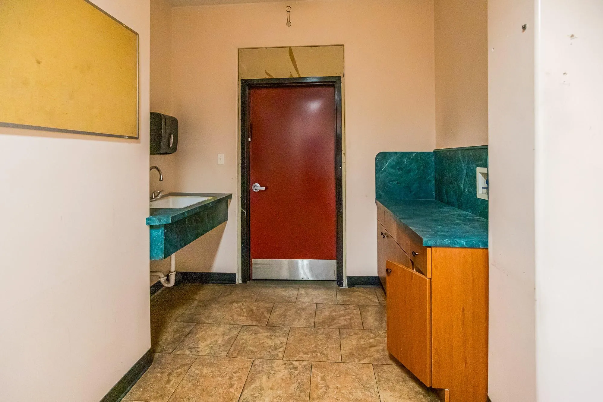 Corridor with baseboards, a sink, and light stone finish floors Corridor with baseboards, a sink, and light stone finish floors