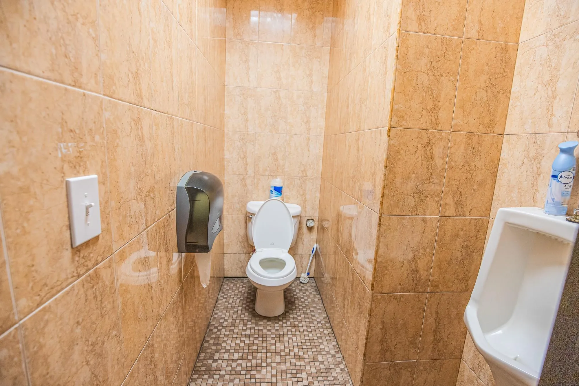 Bathroom featuring tile walls, toilet, and tile patterned flooring Bathroom featuring tile walls, toilet, and tile patterned flooring