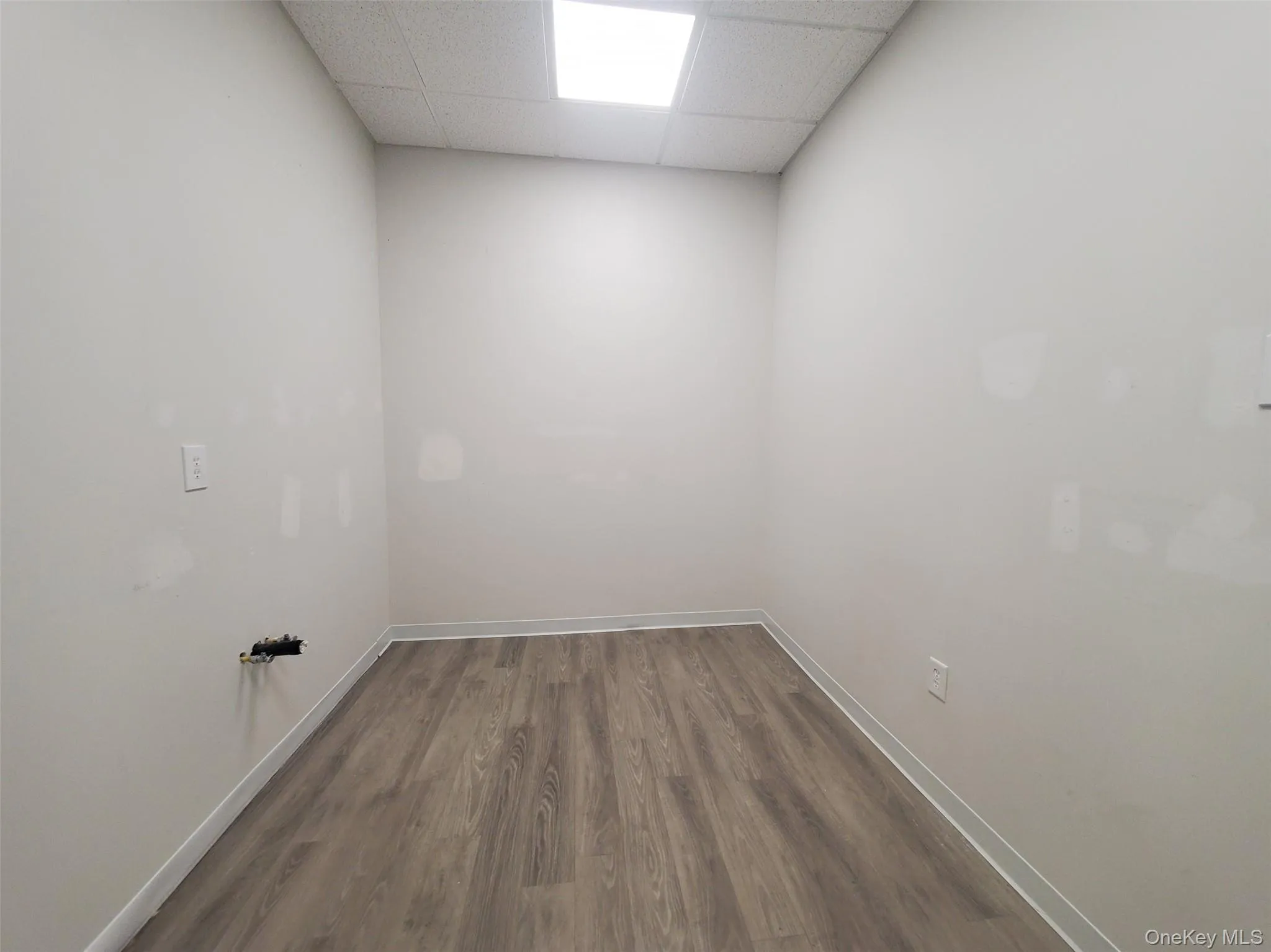 Washroom featuring dark wood-type flooring and baseboards Washroom featuring dark wood-type flooring and baseboards