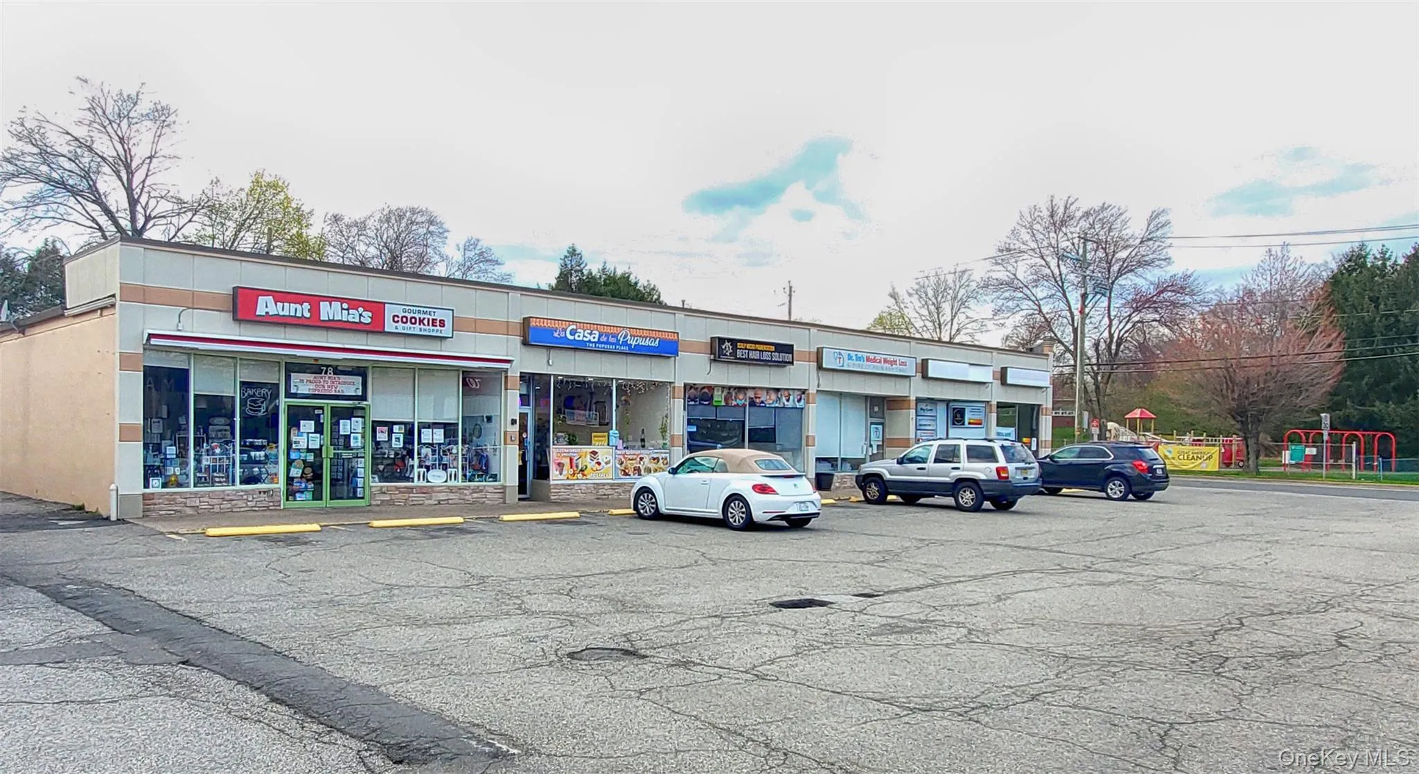 View of commercial property with uncovered parking View of commercial property with uncovered parking
