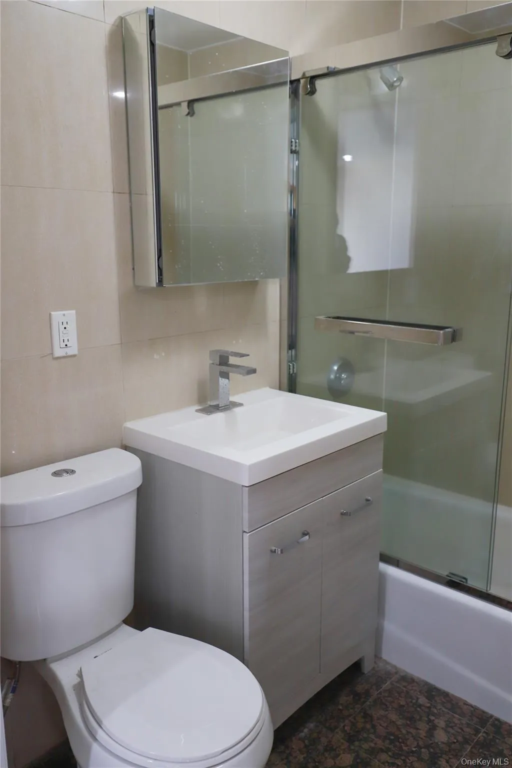 Full bath with vanity, enclosed tub / shower combo, and tile walls Full bath with vanity, enclosed tub / shower combo, and tile walls