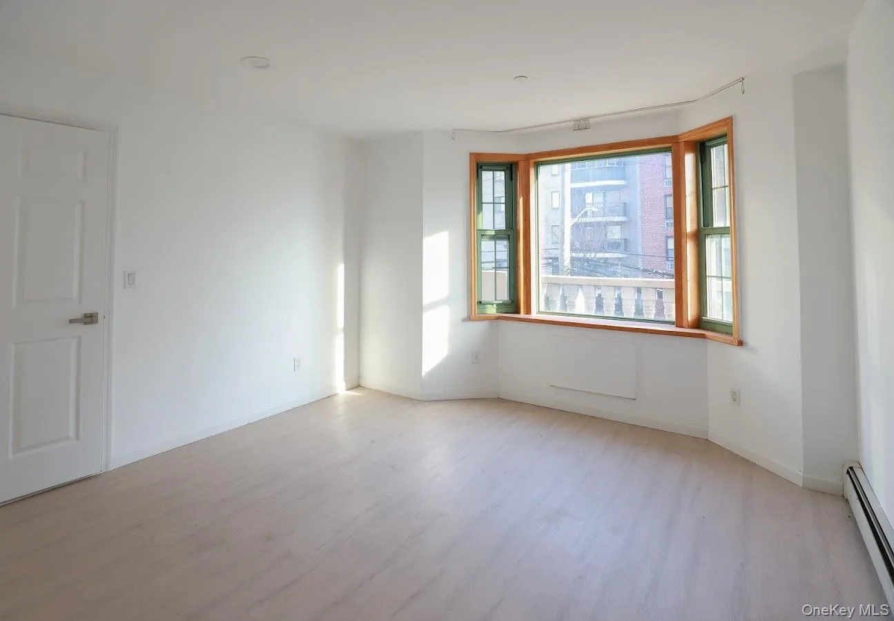 Spare room with a baseboard radiator and light wood-type flooring Spare room with a baseboard radiator and light wood-type flooring