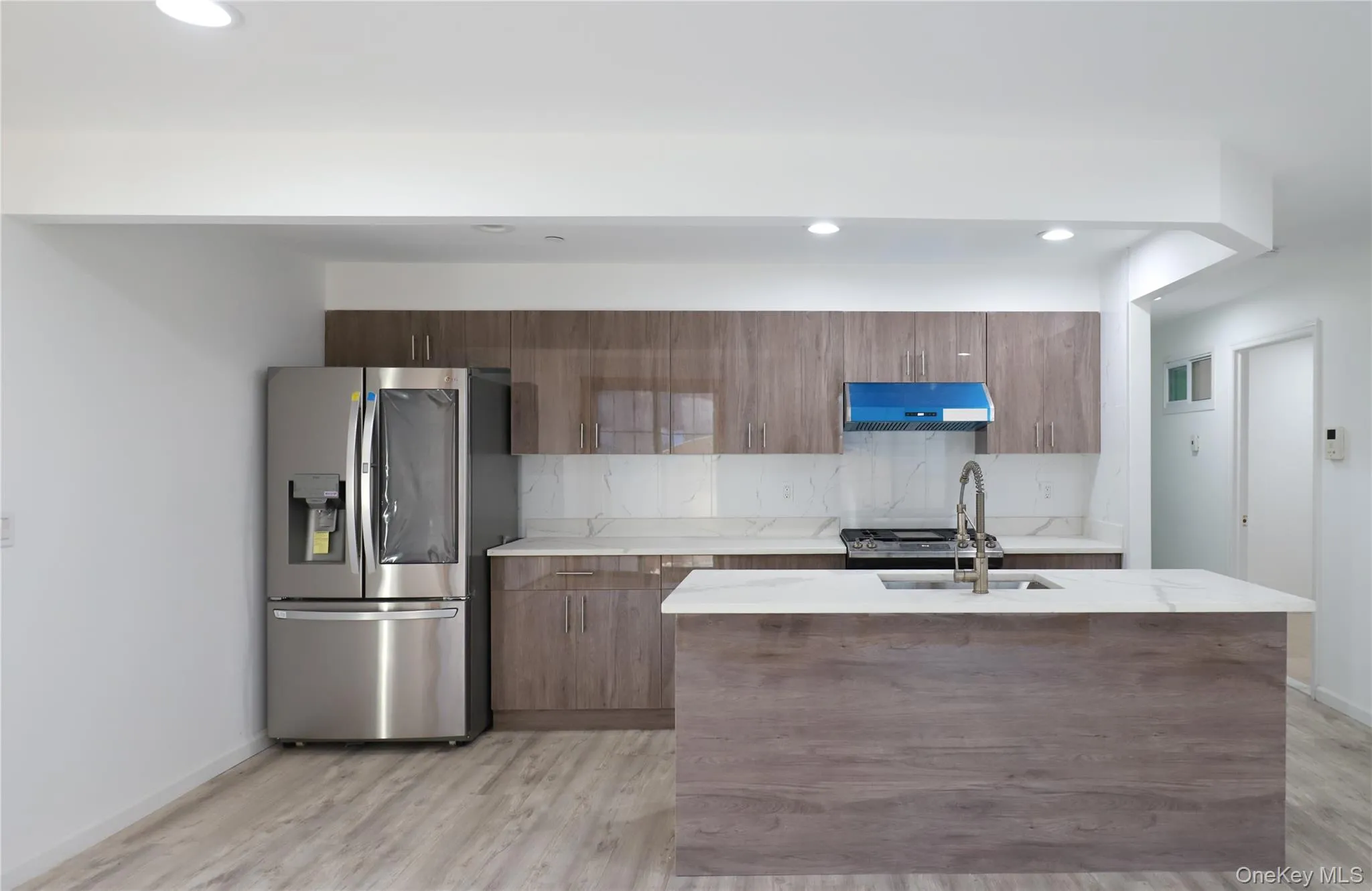 Kitchen with stainless steel appliances, tasteful backsplash, light stone countertops, recessed lighting, and modern cabinets Kitchen with stainless steel appliances, tasteful backsplash, light stone countertops, recessed lighting, and modern cabinets