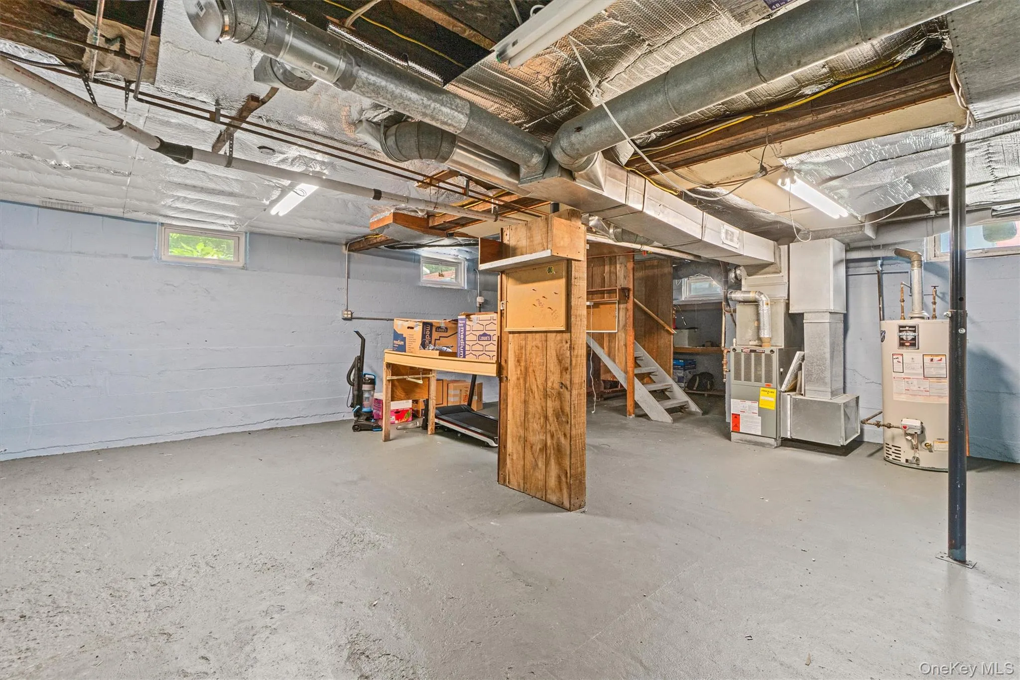 Basement featuring gas water heater, heating unit, and a workshop area Basement featuring gas water heater, heating unit, and a workshop area
