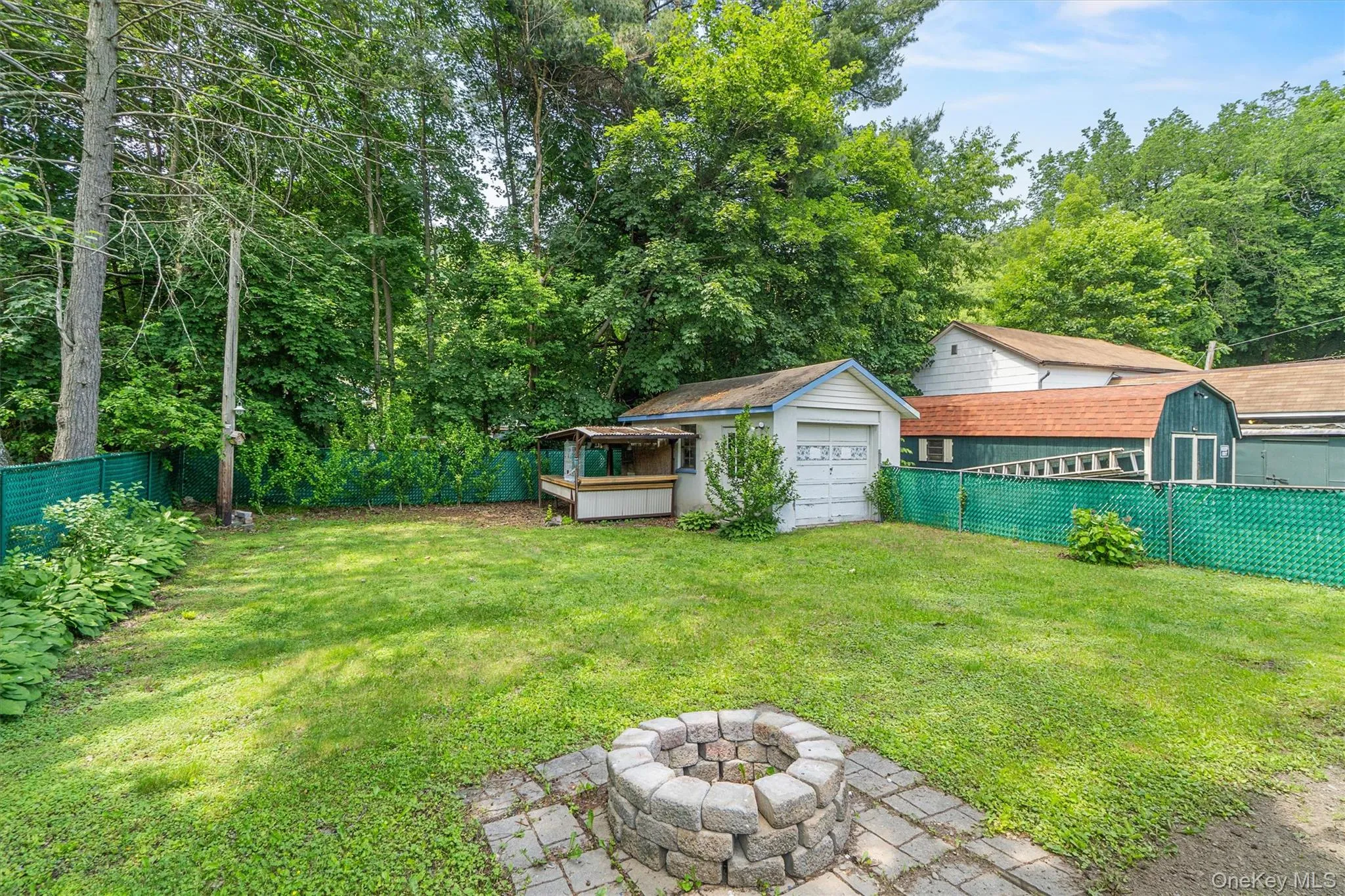 View of yard with an outdoor fire pit and a detached garage View of yard with an outdoor fire pit and a detached garage