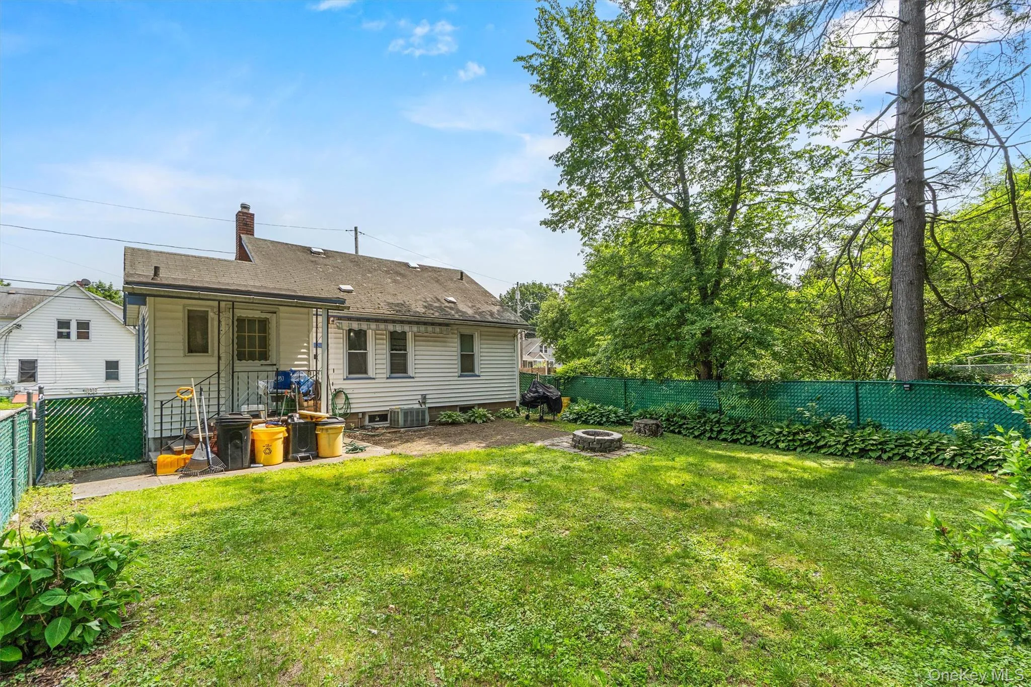 Rear view of property featuring a fire pit and a chimney Rear view of property featuring a fire pit and a chimney