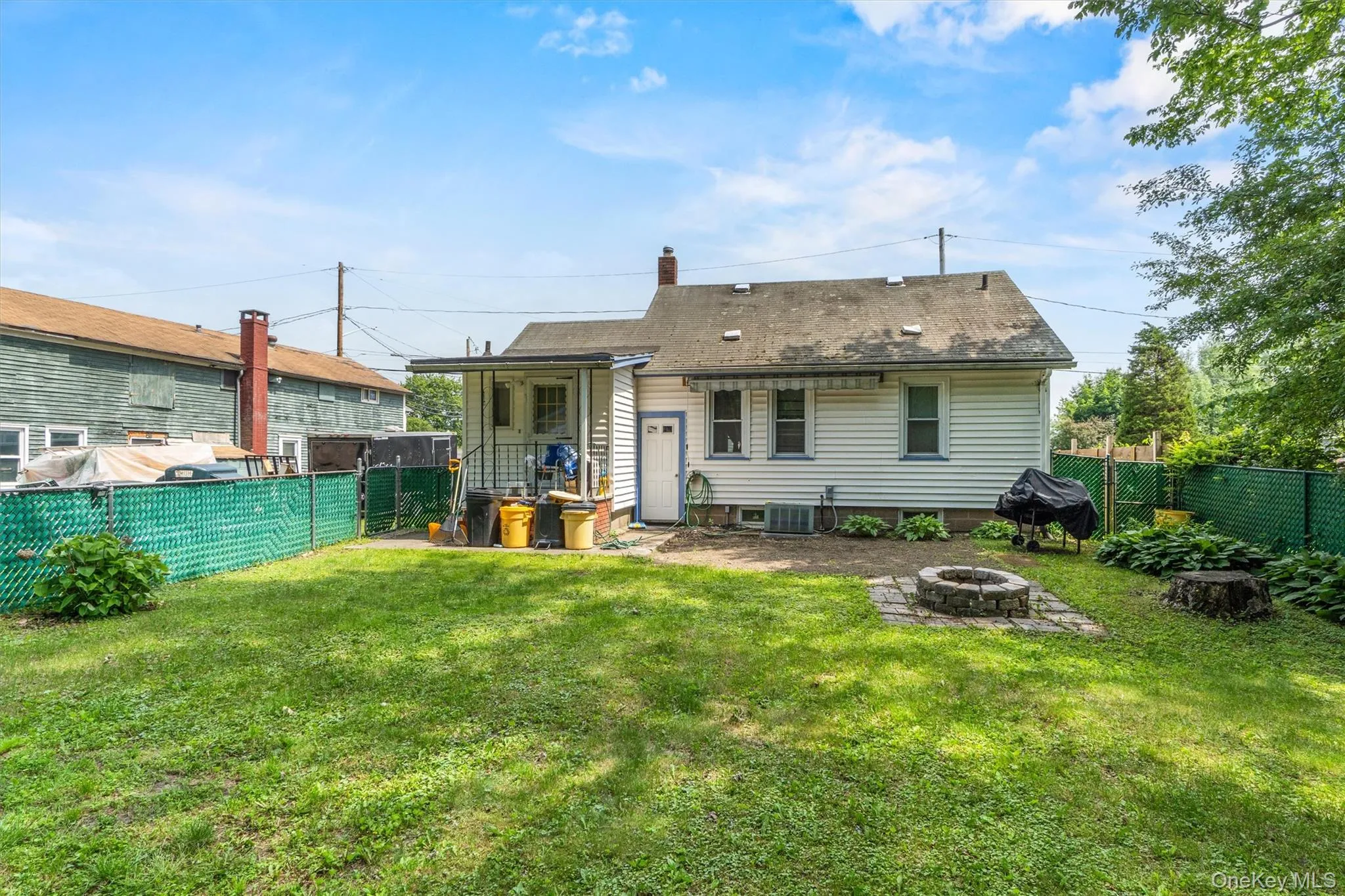 Back of property featuring an outdoor fire pit, cooling unit, and a chimney Back of property featuring an outdoor fire pit, cooling unit, and a chimney