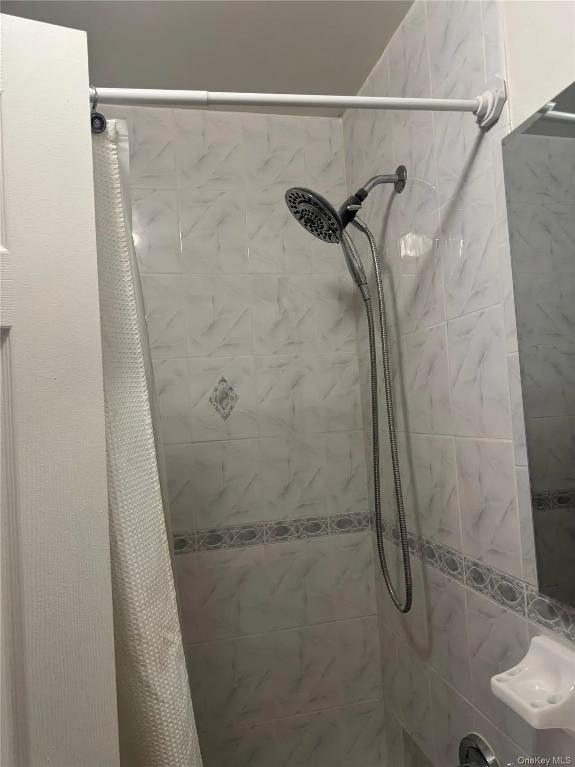 Full bathroom featuring a tile shower Full bathroom featuring a tile shower