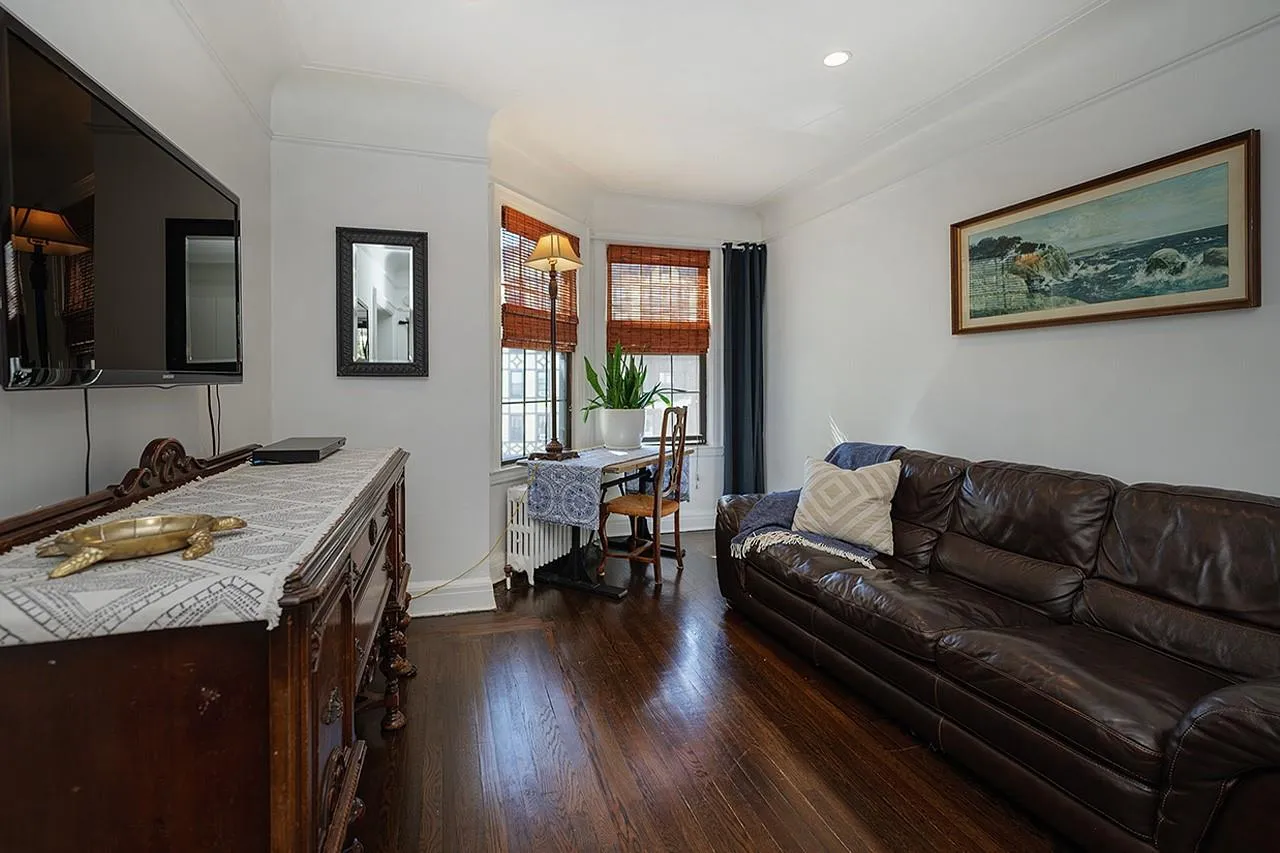 Living area featuring dark wood-style floors, baseboards, and crown molding Living area featuring dark wood-style floors, baseboards, and crown molding