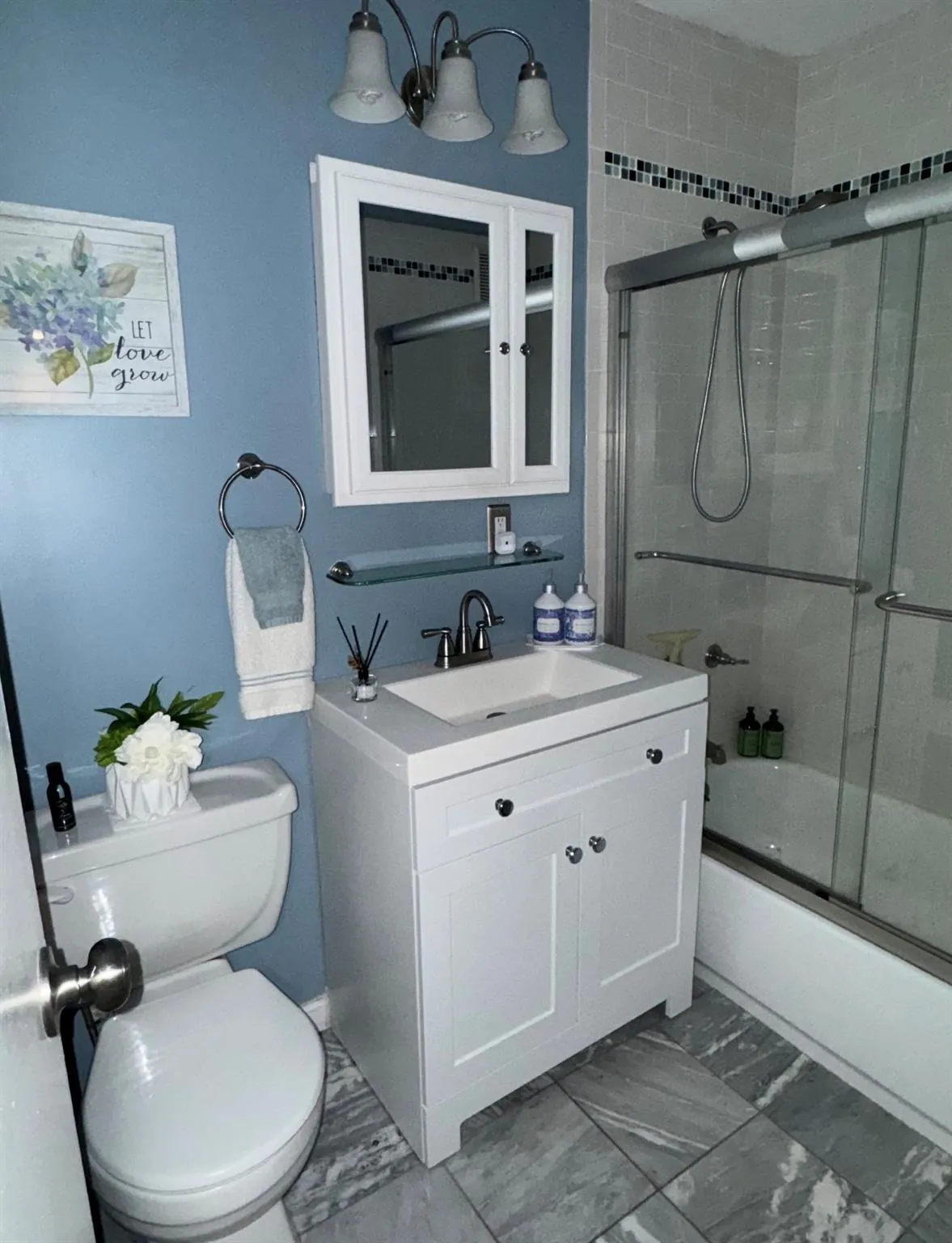Bathroom with toilet, vanity, and shower / bath combination with glass door Bathroom with toilet, vanity, and shower / bath combination with glass door
