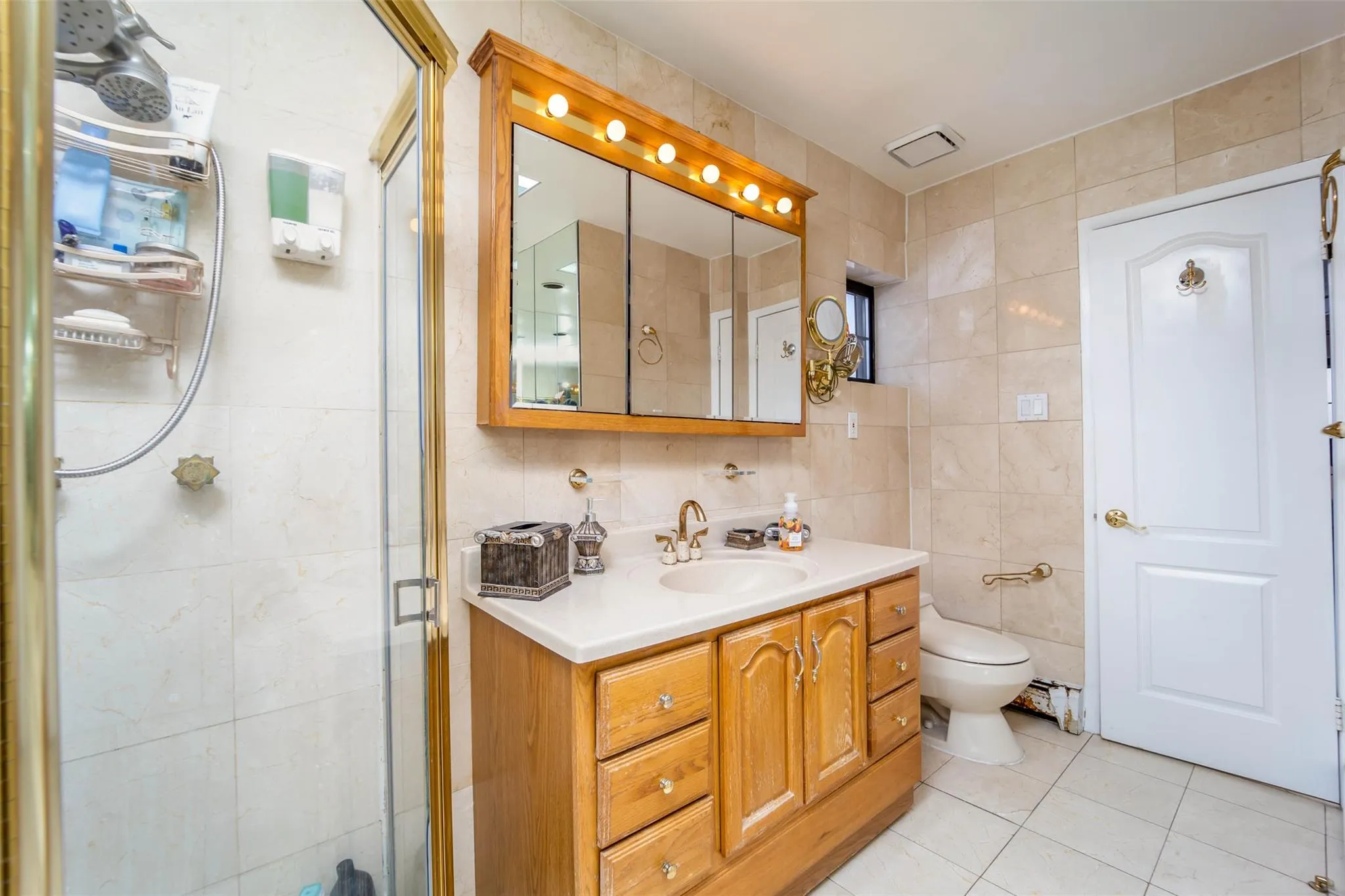 PRIMARY BATHROOM SUITE Bathroom with tile walls, tile patterned floors, vanity, a stall shower, and toilet PRIMARY BATHROOM SUITE Bathroom with tile walls, tile patterned floors, vanity, a stall shower, and toilet