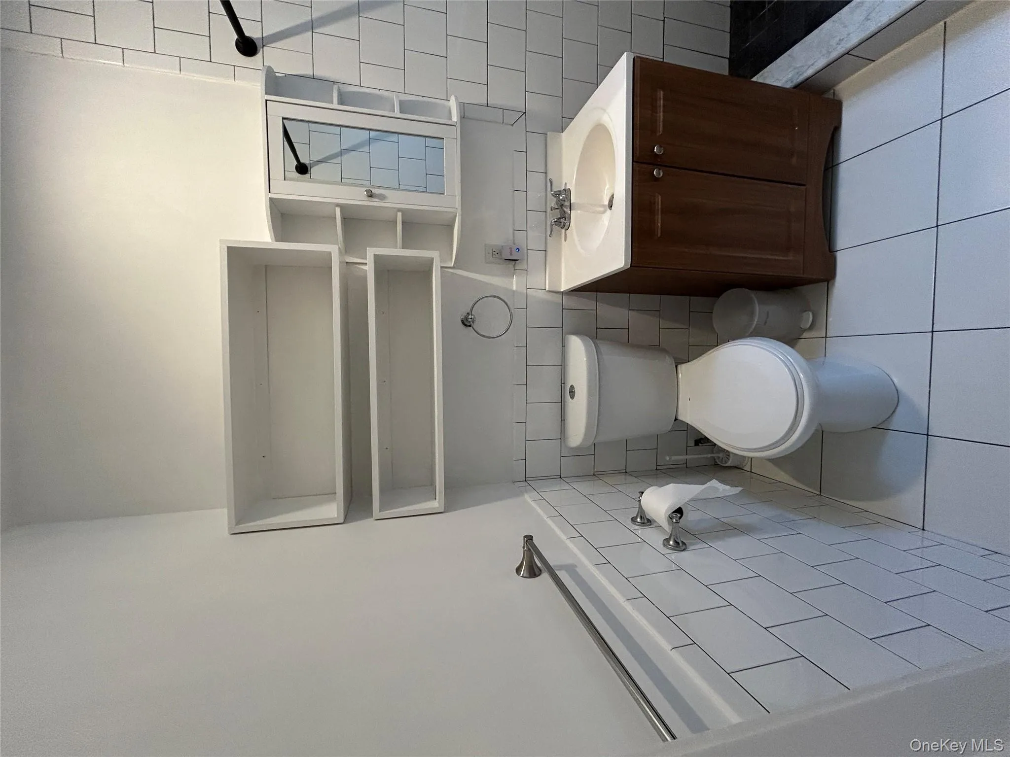 Bathroom with tile walls, light tile patterned flooring, vanity, tiled shower, and wainscoting Bathroom with tile walls, light tile patterned flooring, vanity, tiled shower, and wainscoting