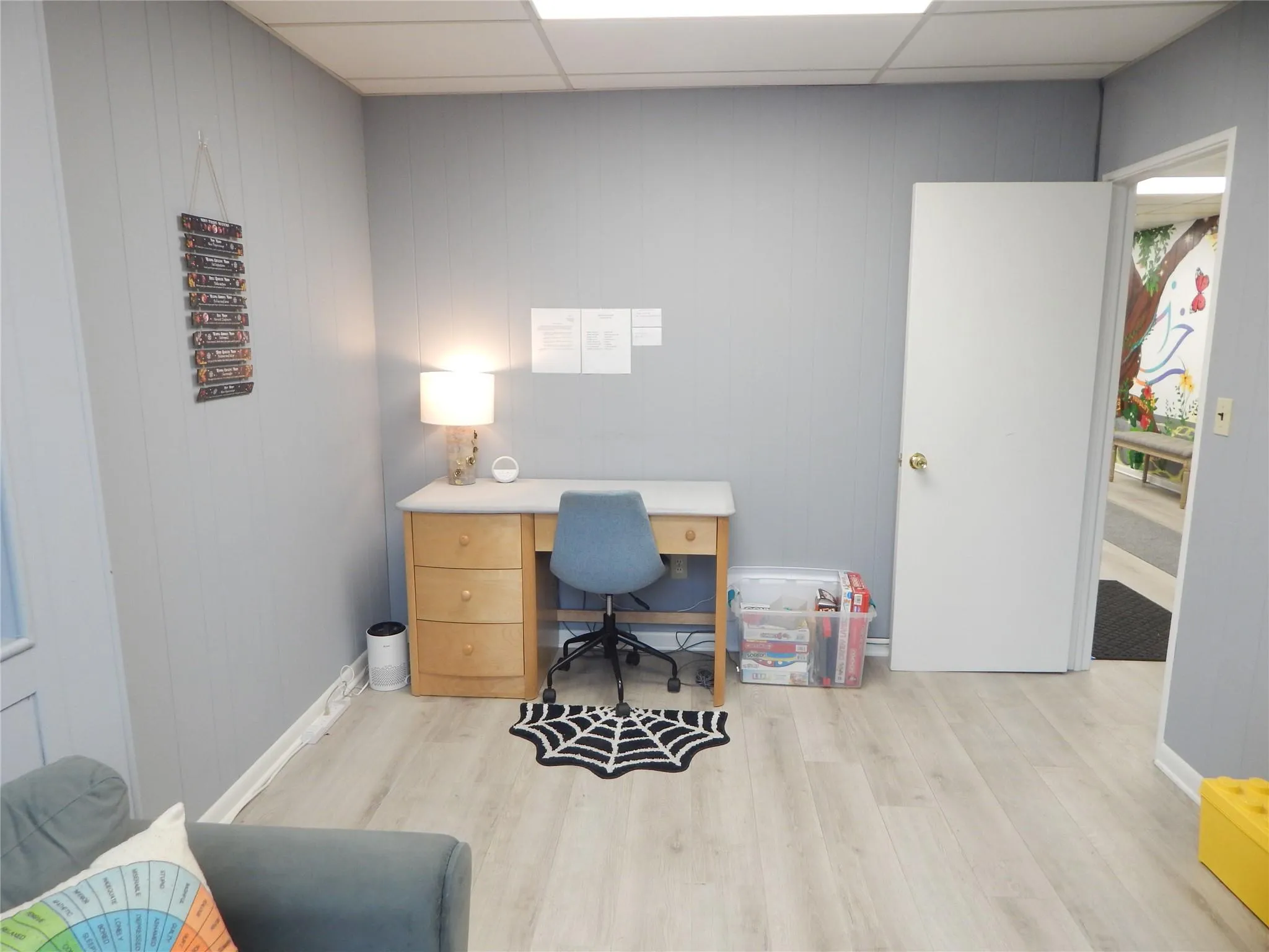 Office with a paneled ceiling and light hardwood / wood-style flooring Office with a paneled ceiling and light hardwood / wood-style flooring