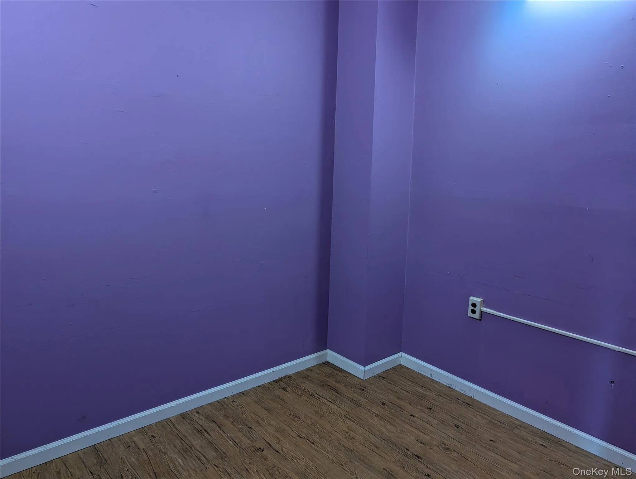 Unfurnished room with wood finished floors and baseboards Unfurnished room with wood finished floors and baseboards