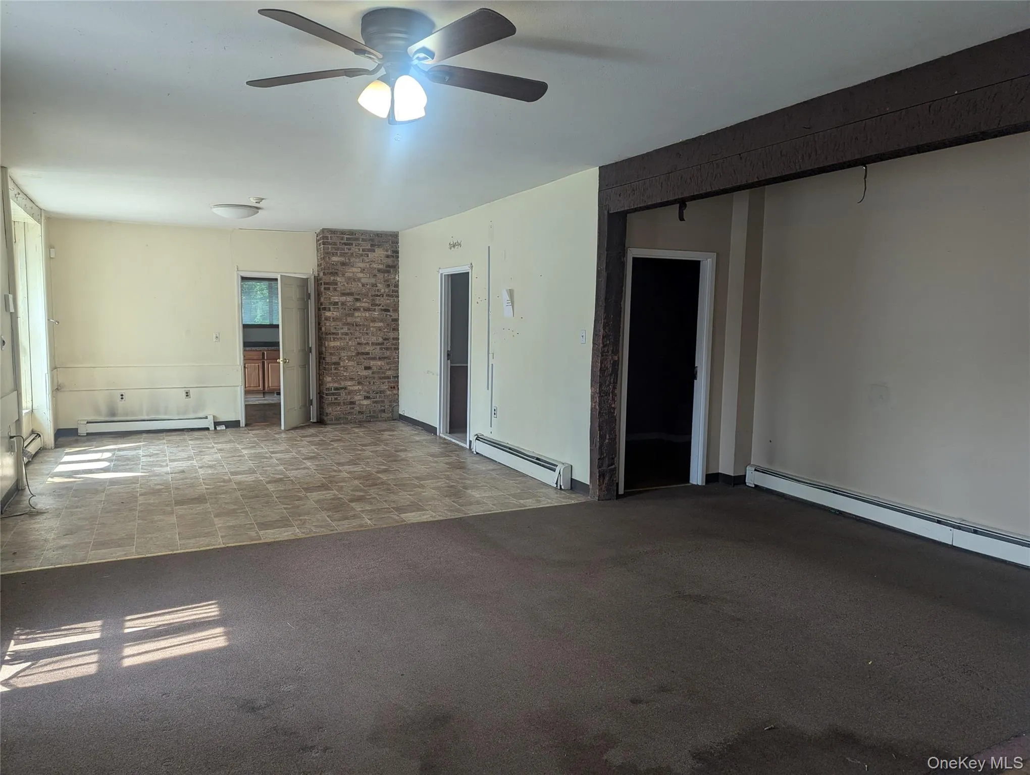Unfurnished room featuring a baseboard heating unit and a ceiling fan Unfurnished room featuring a baseboard heating unit and a ceiling fan