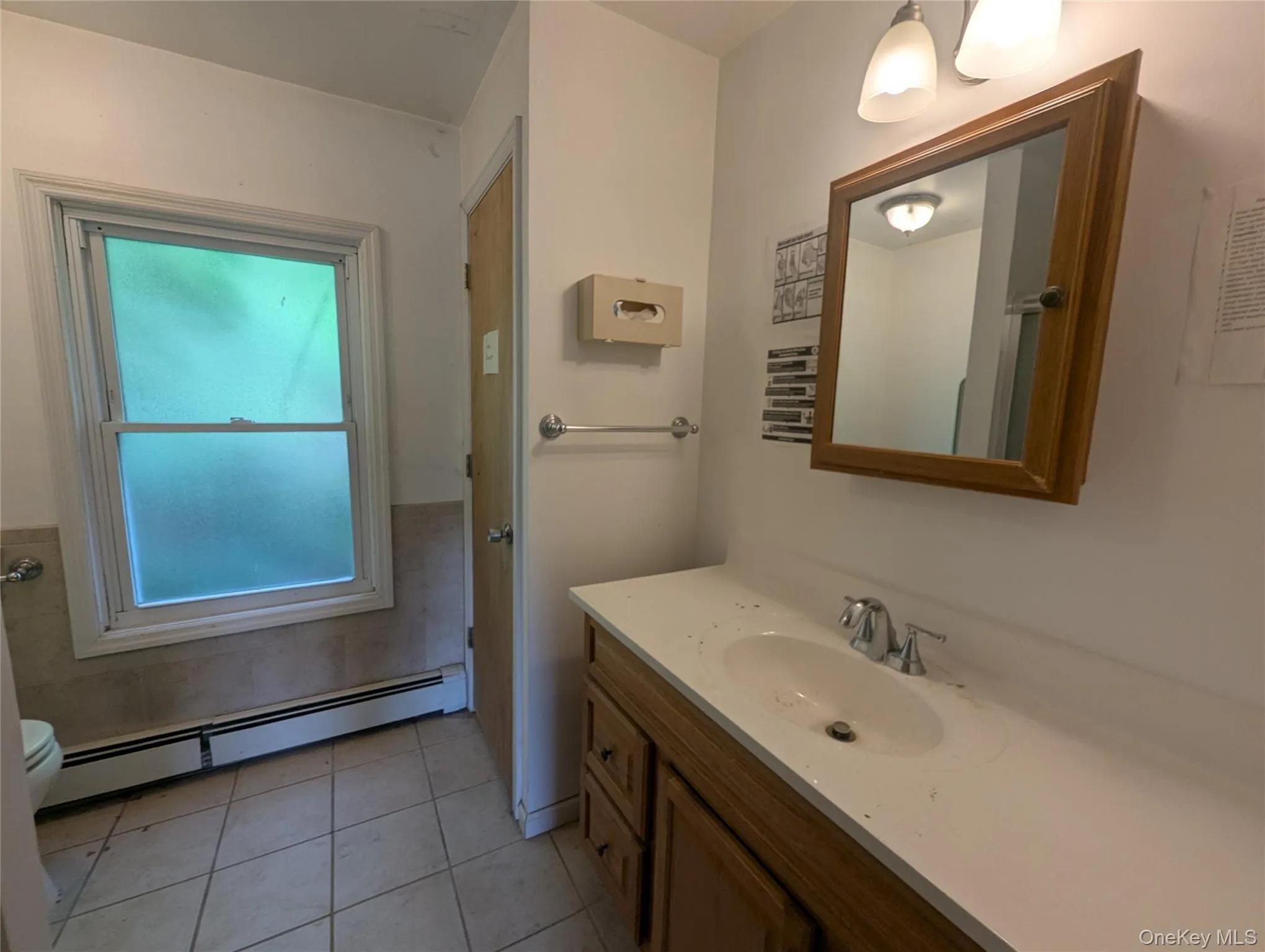 Bathroom featuring a baseboard heating unit, vanity, and tile patterned floors Bathroom featuring a baseboard heating unit, vanity, and tile patterned floors