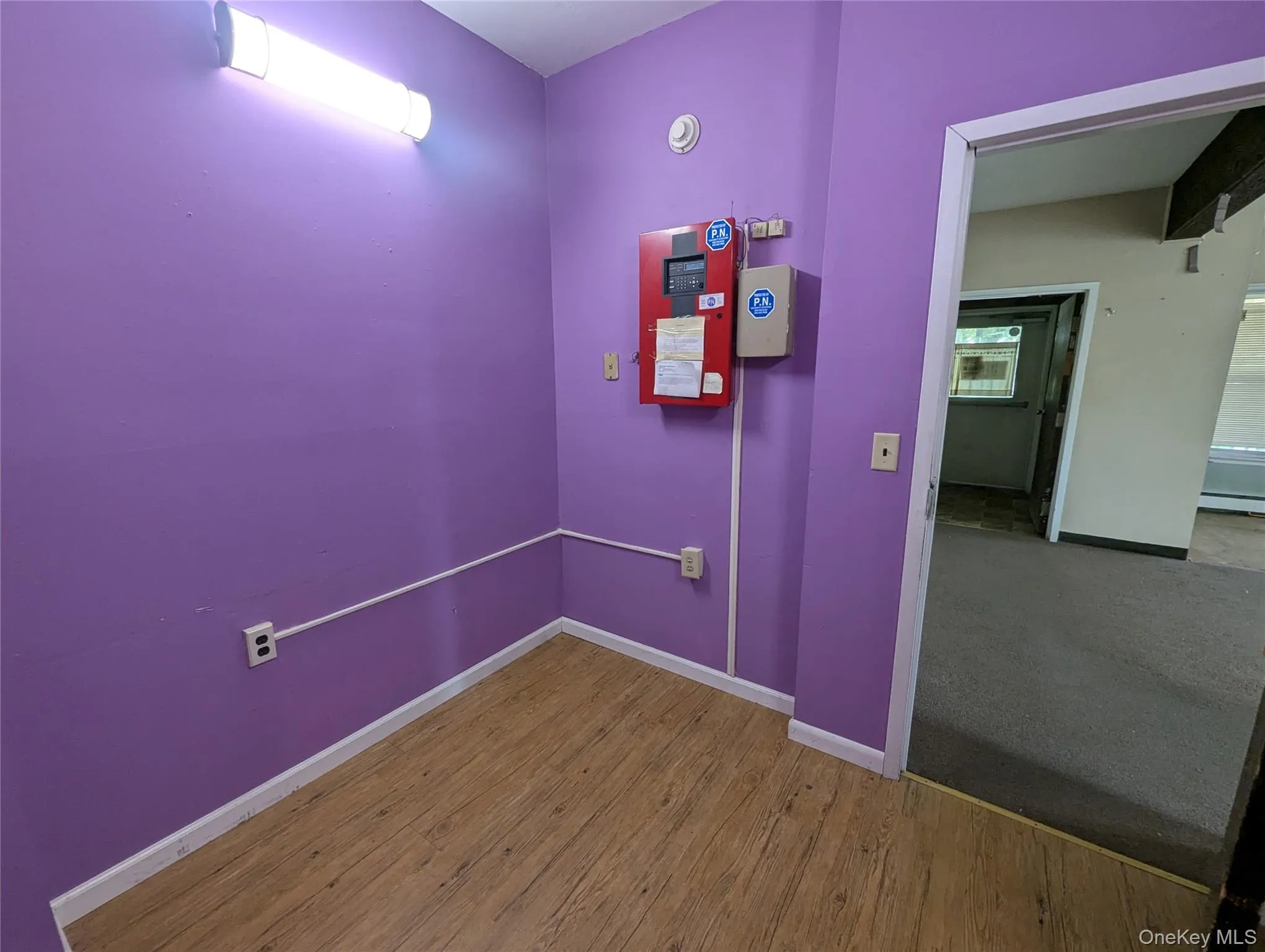 Hallway with wood finished floors and baseboard heating Hallway with wood finished floors and baseboard heating