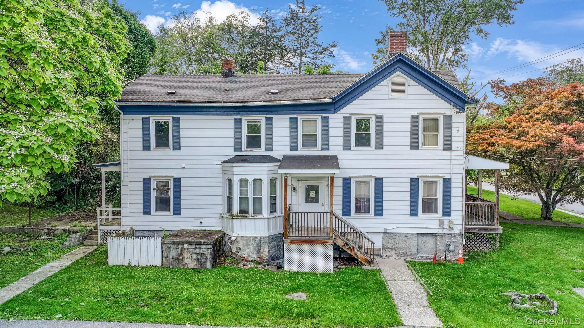 View of front of property with a chimney, a front yard, and roof with shingles View of front of property with a chimney, a front yard, and roof with shingles