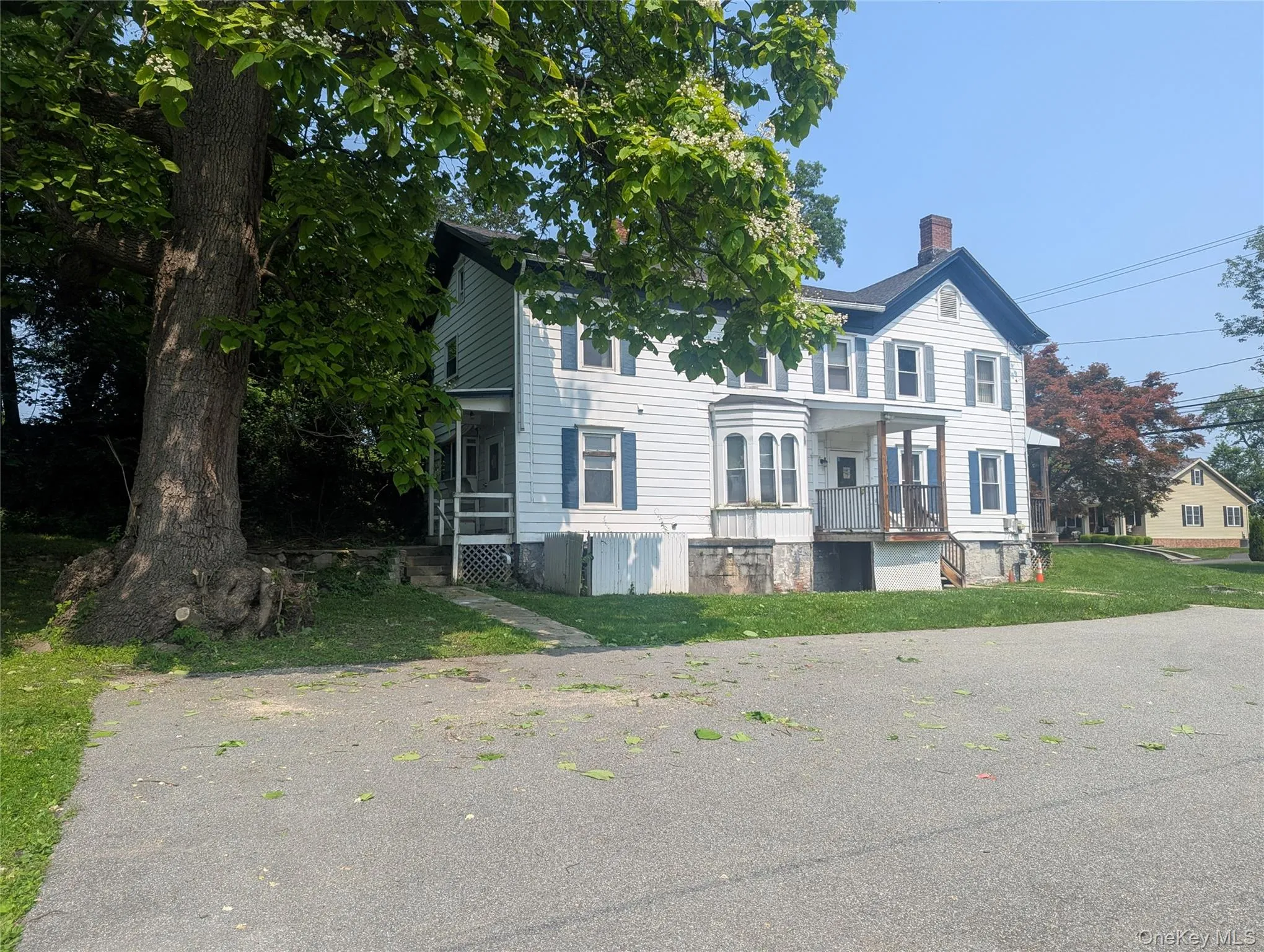 View of front of house featuring a chimney and a front lawn View of front of house featuring a chimney and a front lawn
