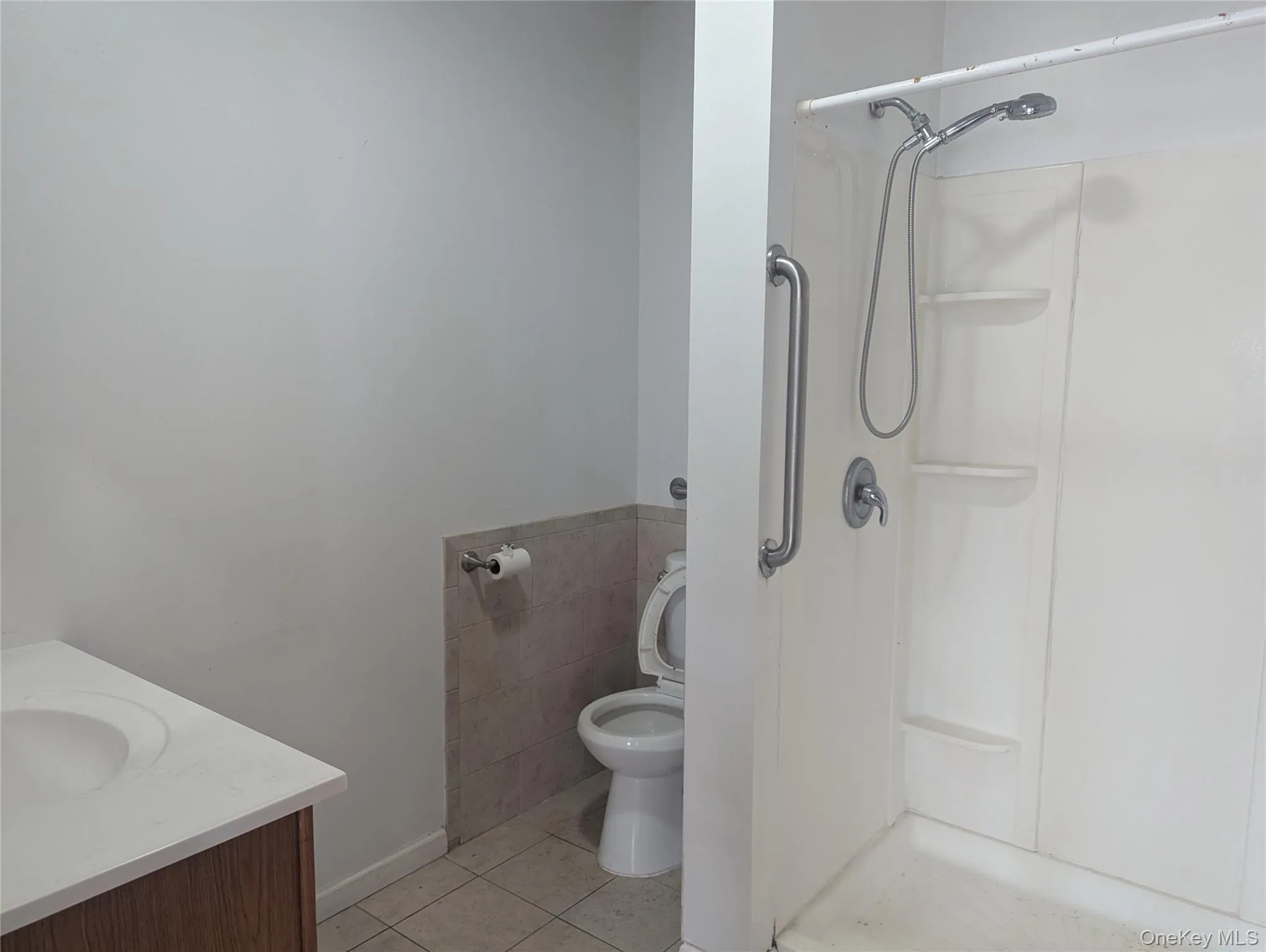 Bathroom featuring tile patterned floors, a shower, and vanity Bathroom featuring tile patterned floors, a shower, and vanity