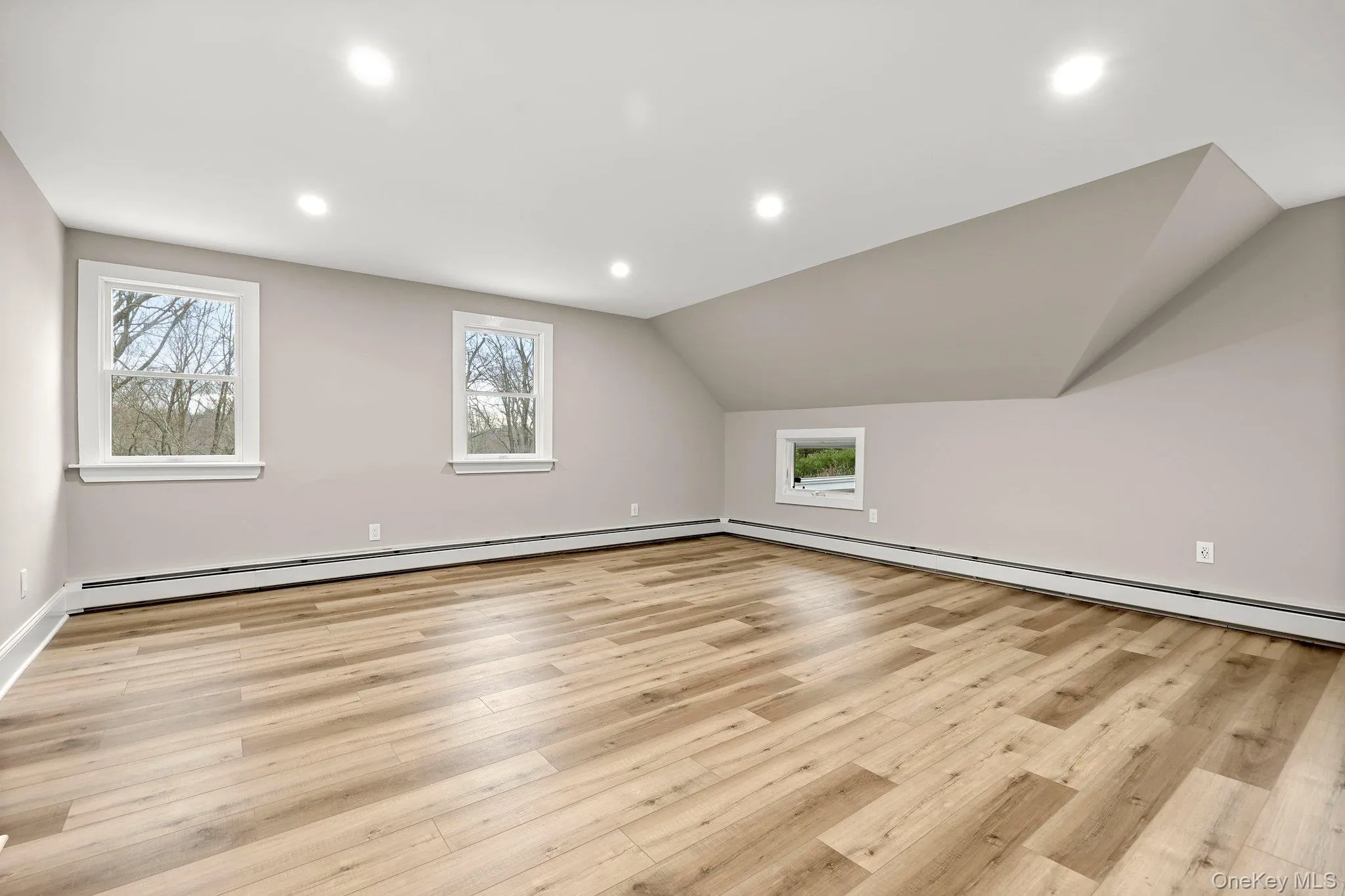 bedroom with lofted ceiling, recessed lighting, and baseboard heating bedroom with lofted ceiling, recessed lighting, and baseboard heating