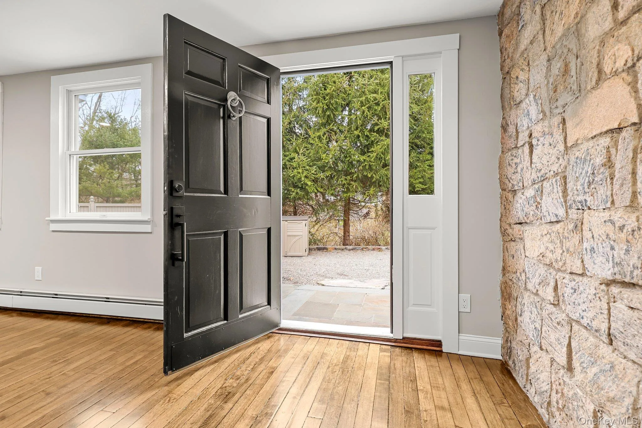 Doorway to outside featuring a baseboard radiator and wood flooring Doorway to outside featuring a baseboard radiator and wood flooring