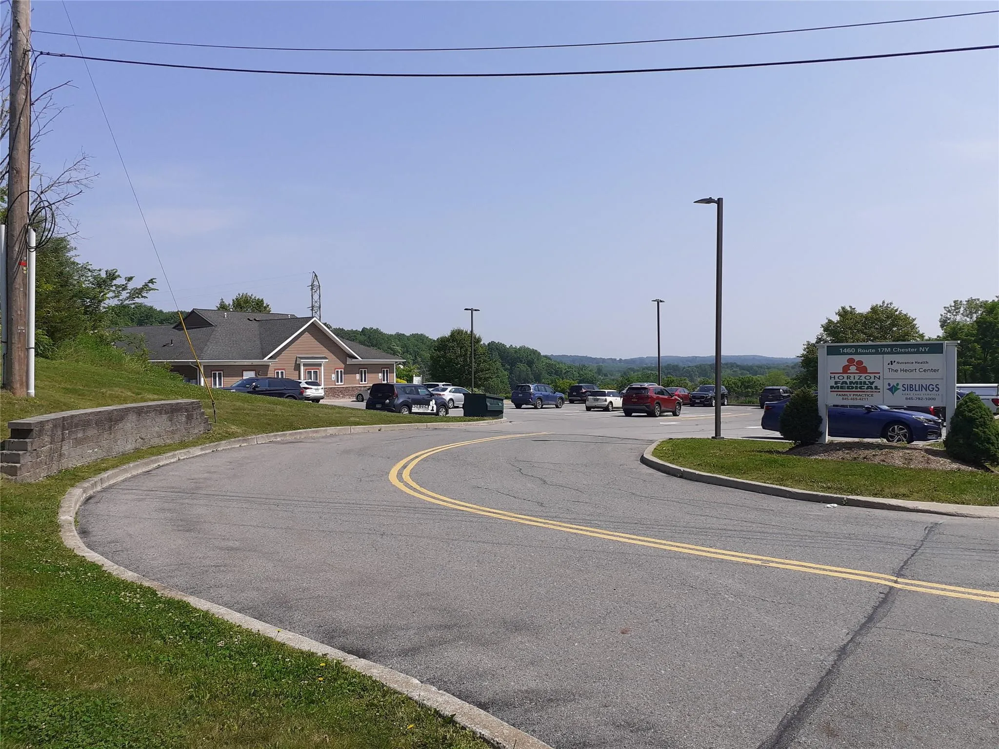 View of asphalt street with curbs and street lights View of asphalt street with curbs and street lights