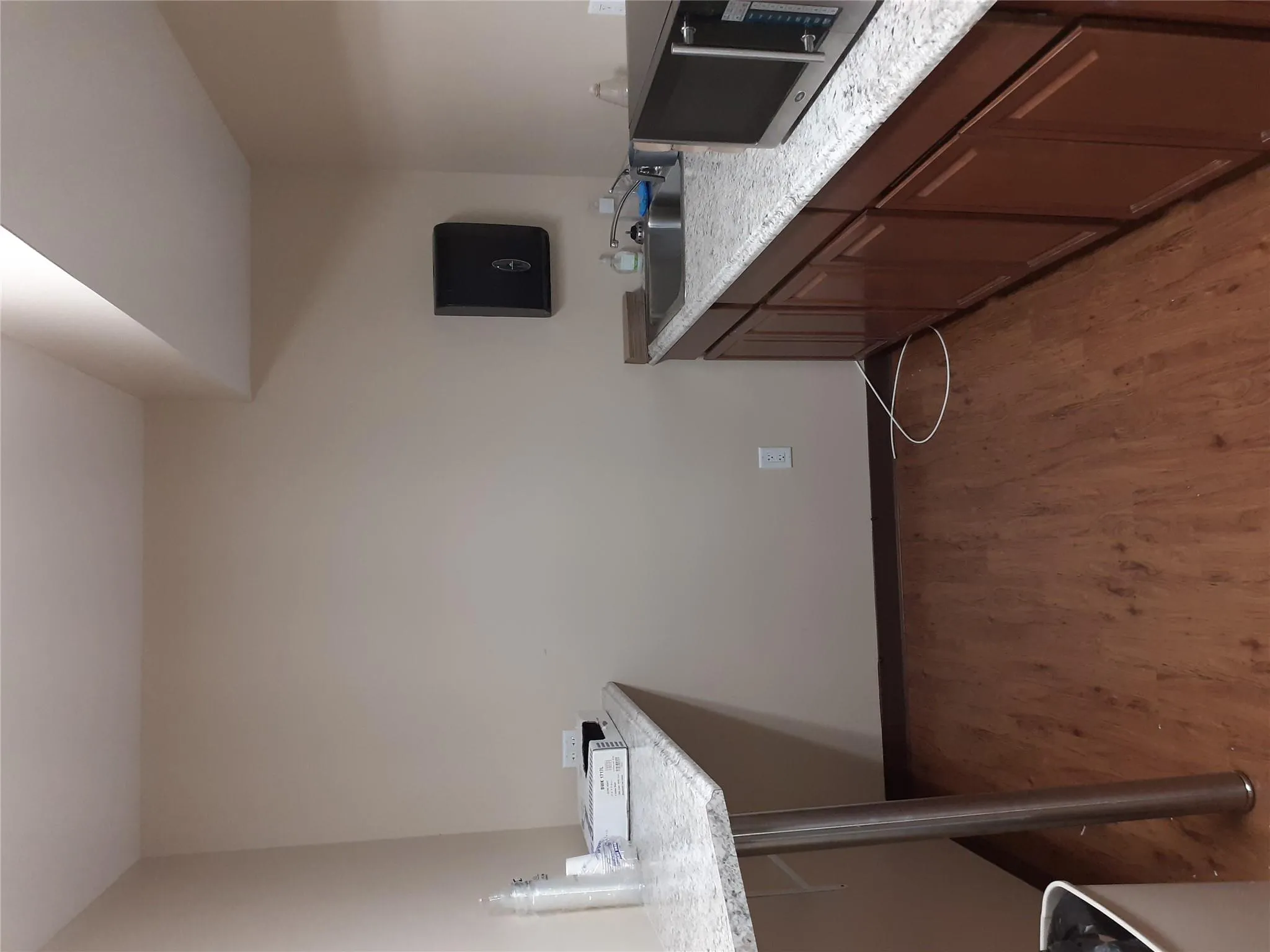 Kitchen featuring a sink, light wood-type flooring, light countertops, and baseboards Kitchen featuring a sink, light wood-type flooring, light countertops, and baseboards