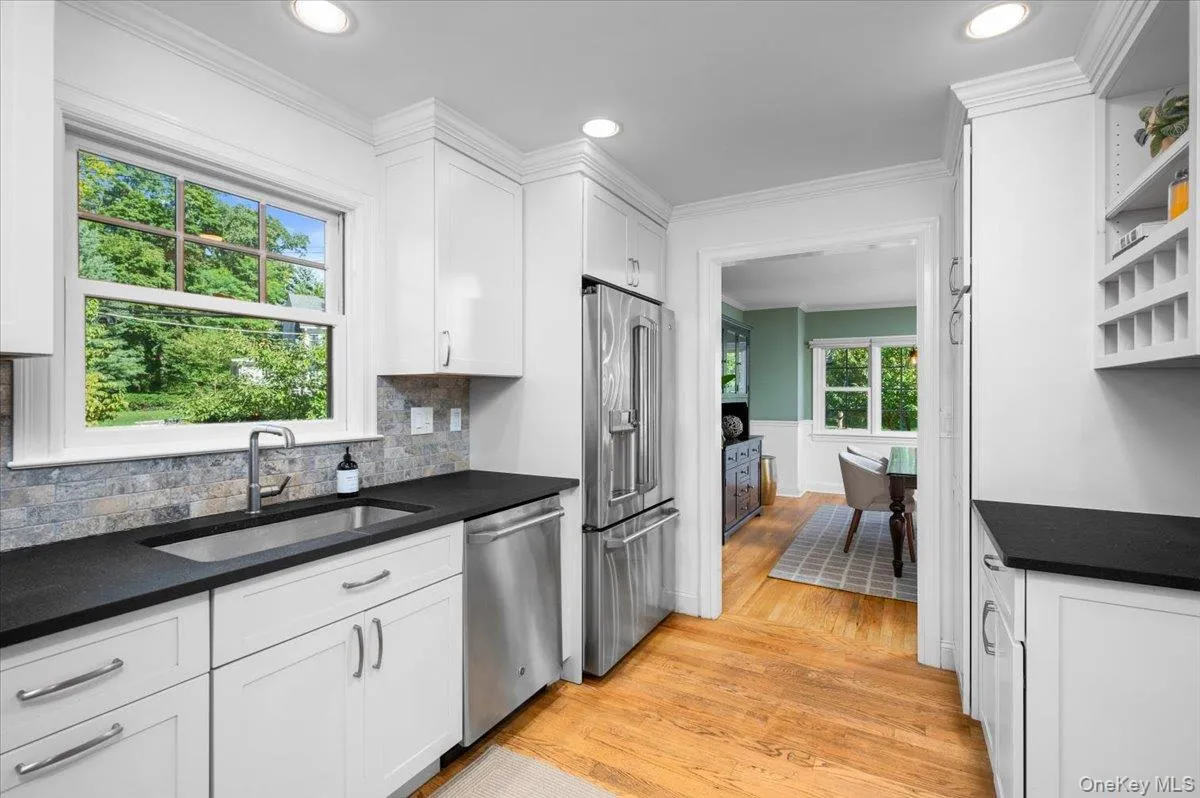 Natural light pours in above the sink, complementing the white cabinetry, stainless steel appliances and warm oak floors of this move-in-ready kitchen. Natural light pours in above the sink, complementing the white cabinetry, stainless steel appliances and warm oak floors of this move-in-ready kitchen.